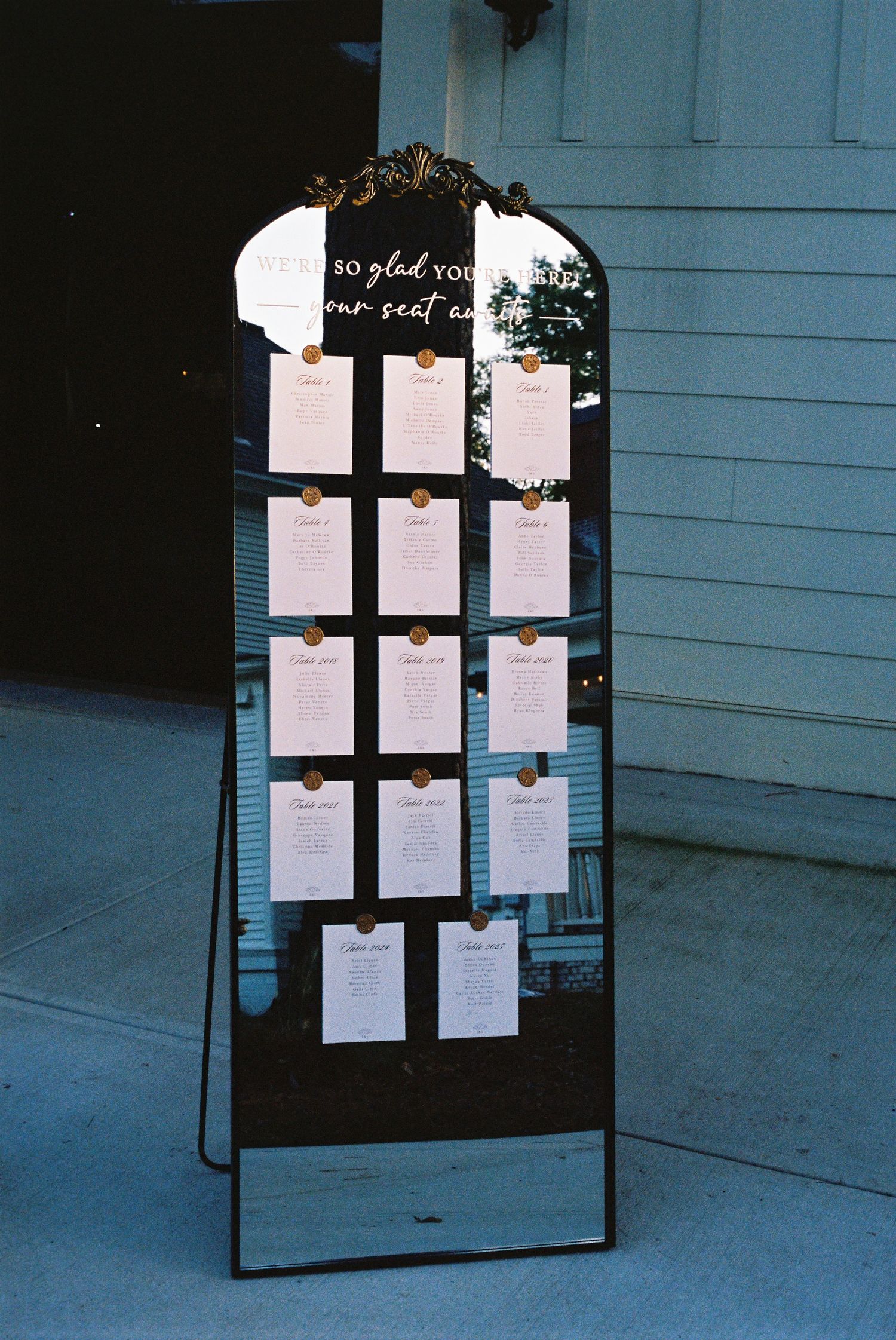 Wedding seating chart displayed on an elegant black frame stand.