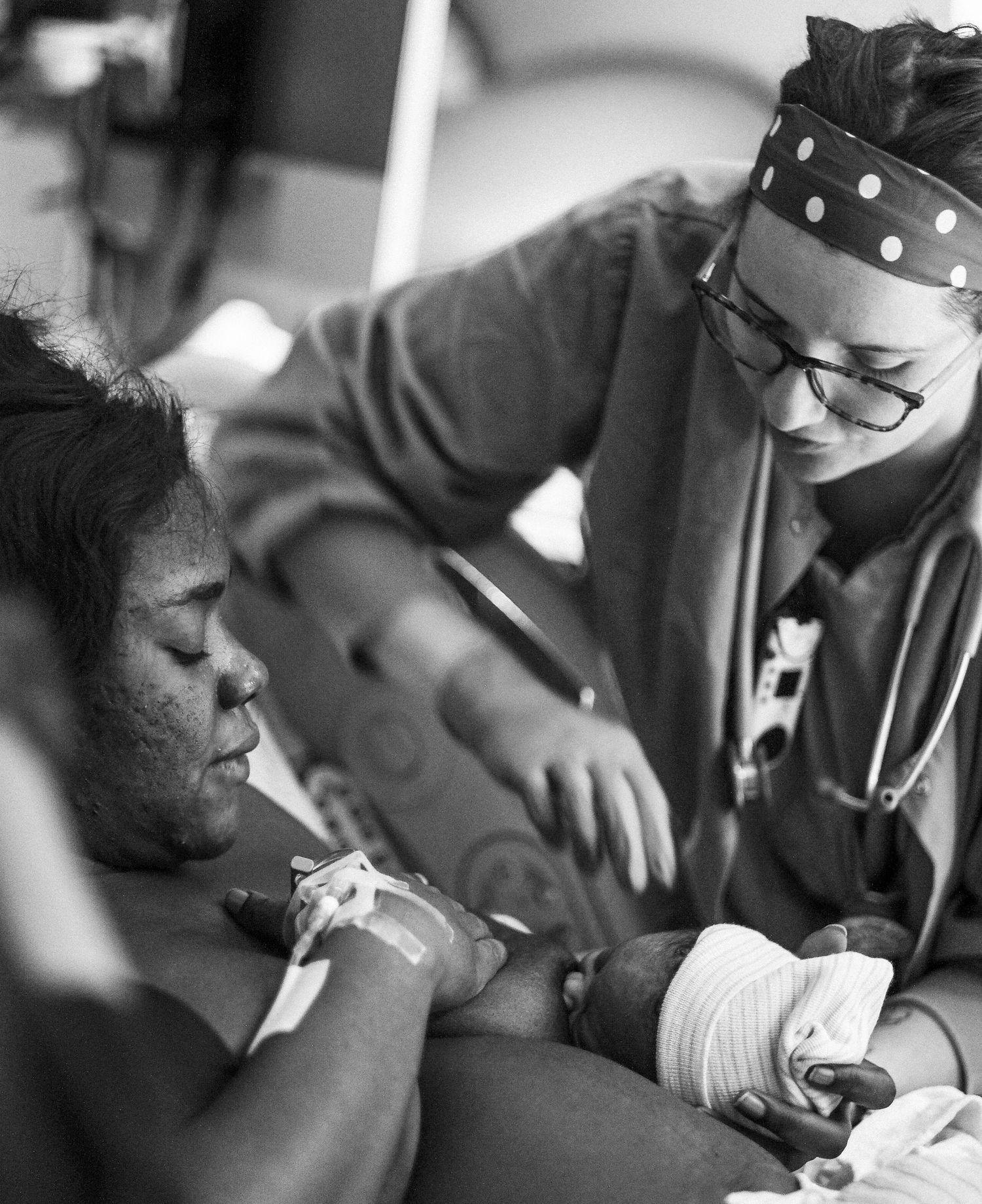 Medical professionals in protective gear attend to a patient during a procedure.