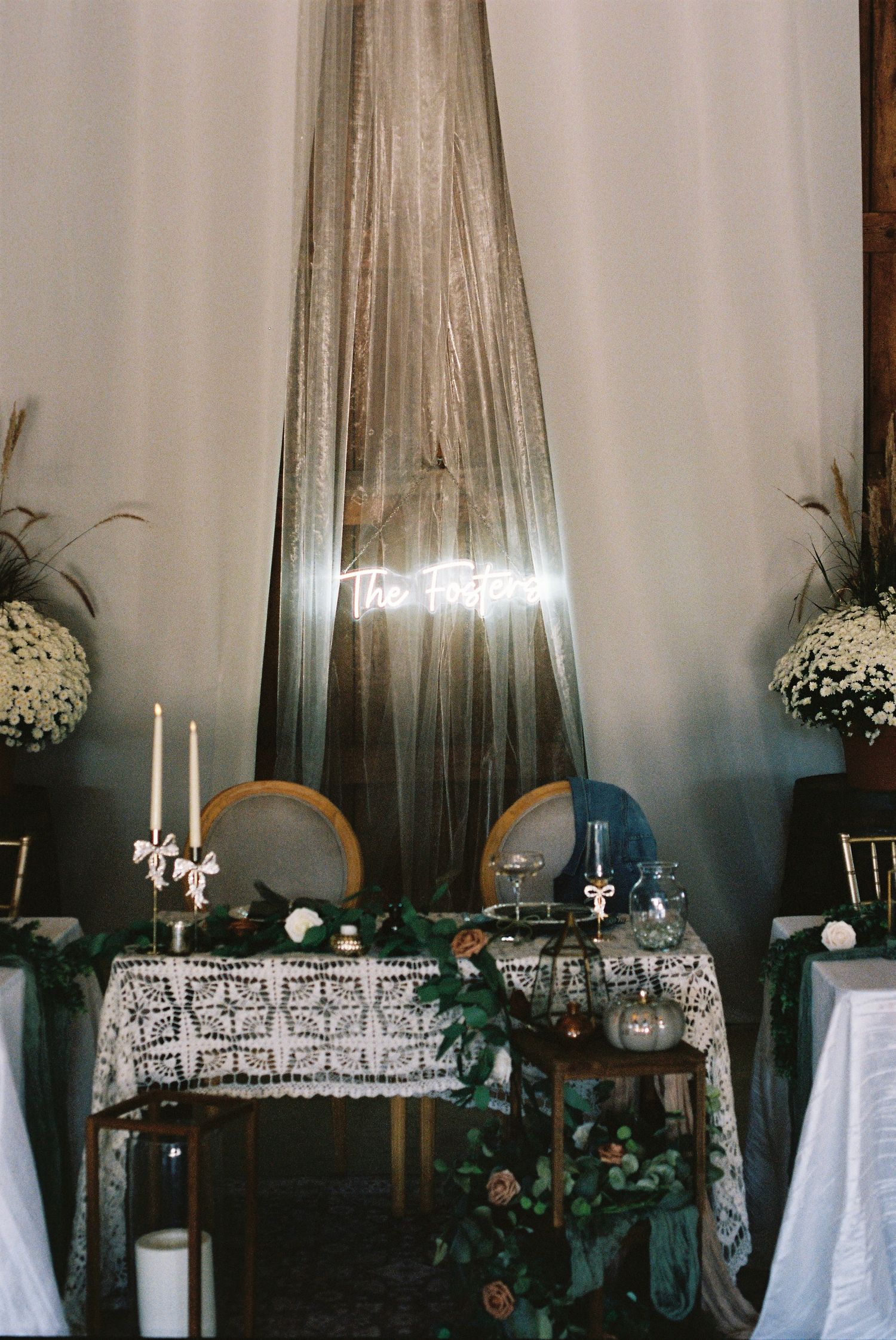 Elegant wedding reception table setup with white linens, candles and floral decorations.