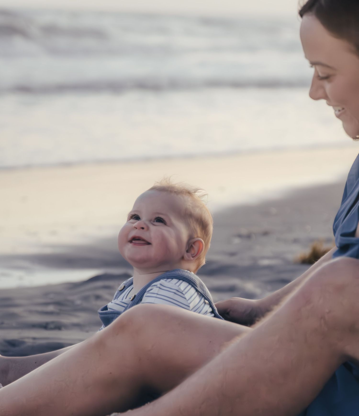 Joyful family moment captured on beach with setting sun.