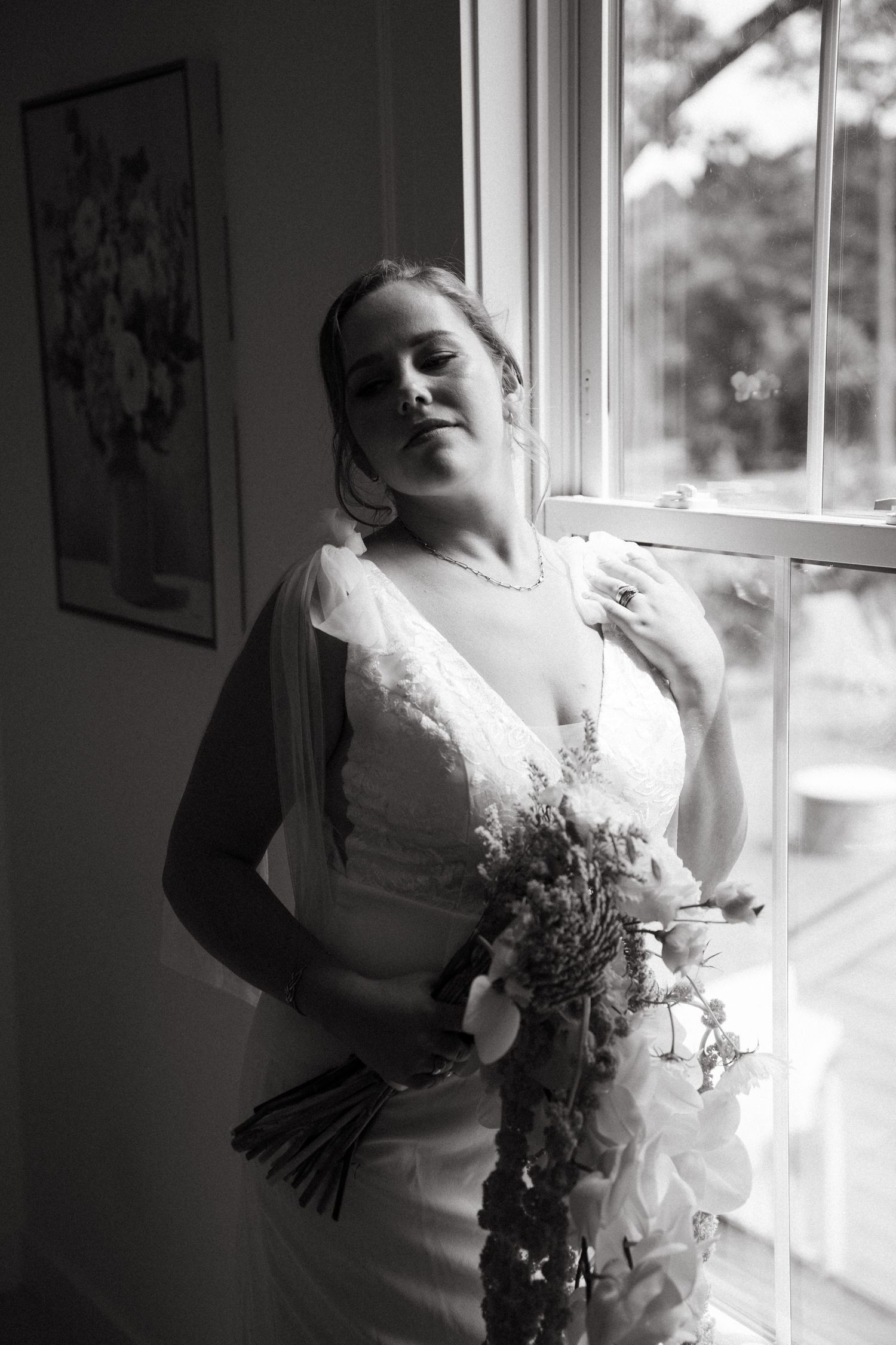 A series of black and white photos showing a person in a white dress posing expressively near a window.