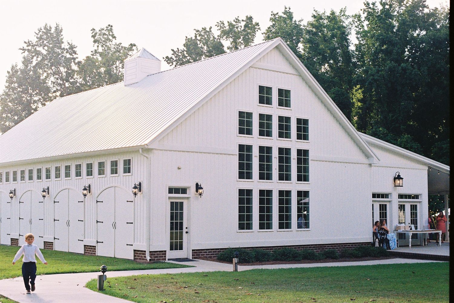 Row of pristine white wedding venue buildings with classic New England architecture.