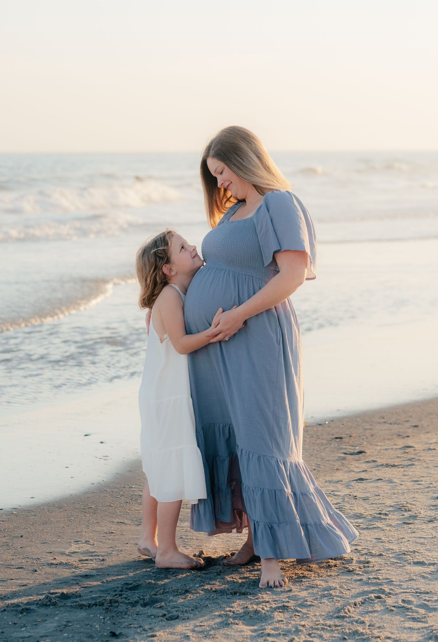 Mother and daughter share an intimate moment together on a peaceful beach.
