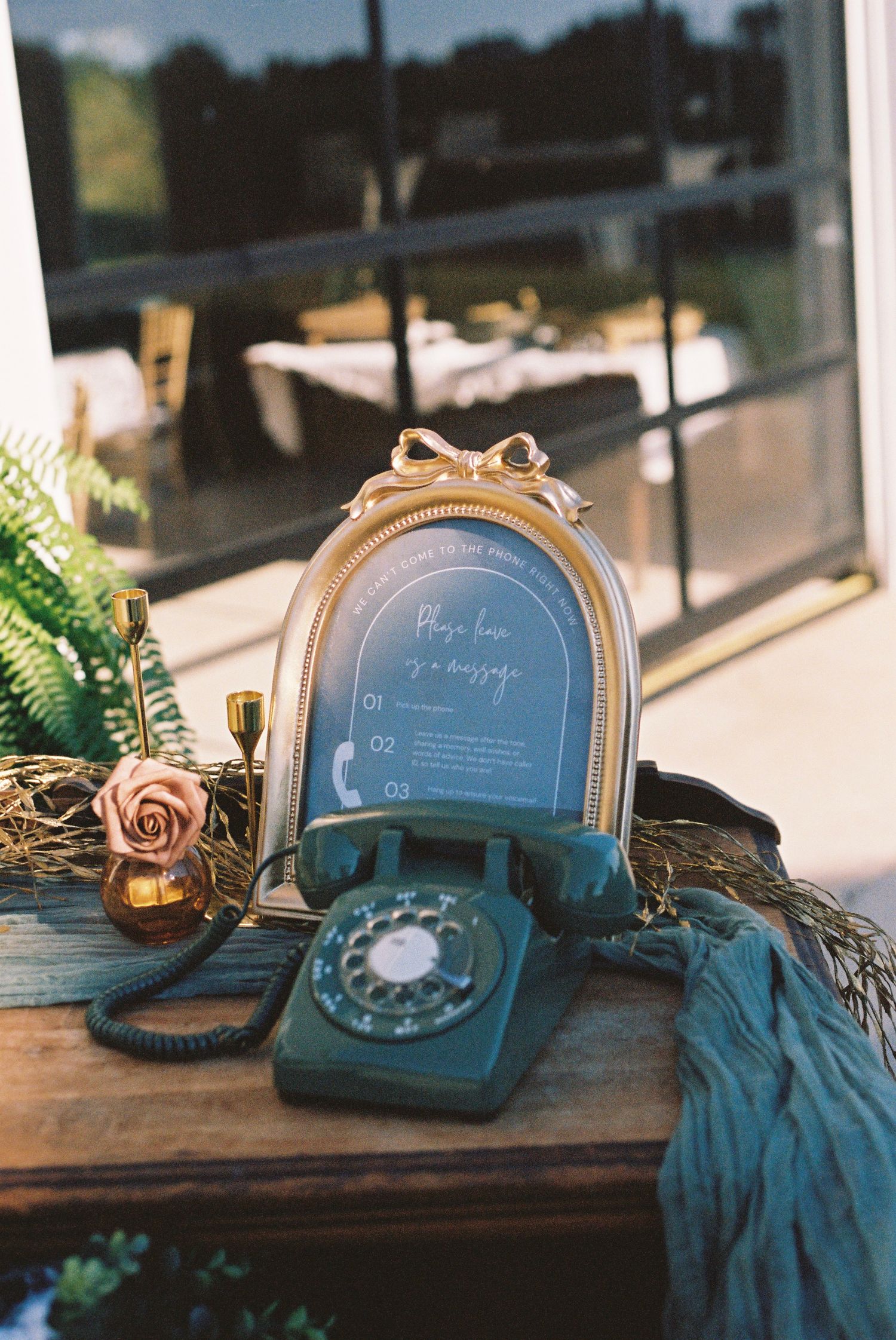 Vintage rotary telephone and decorative items arranged on wooden table for wedding decor.