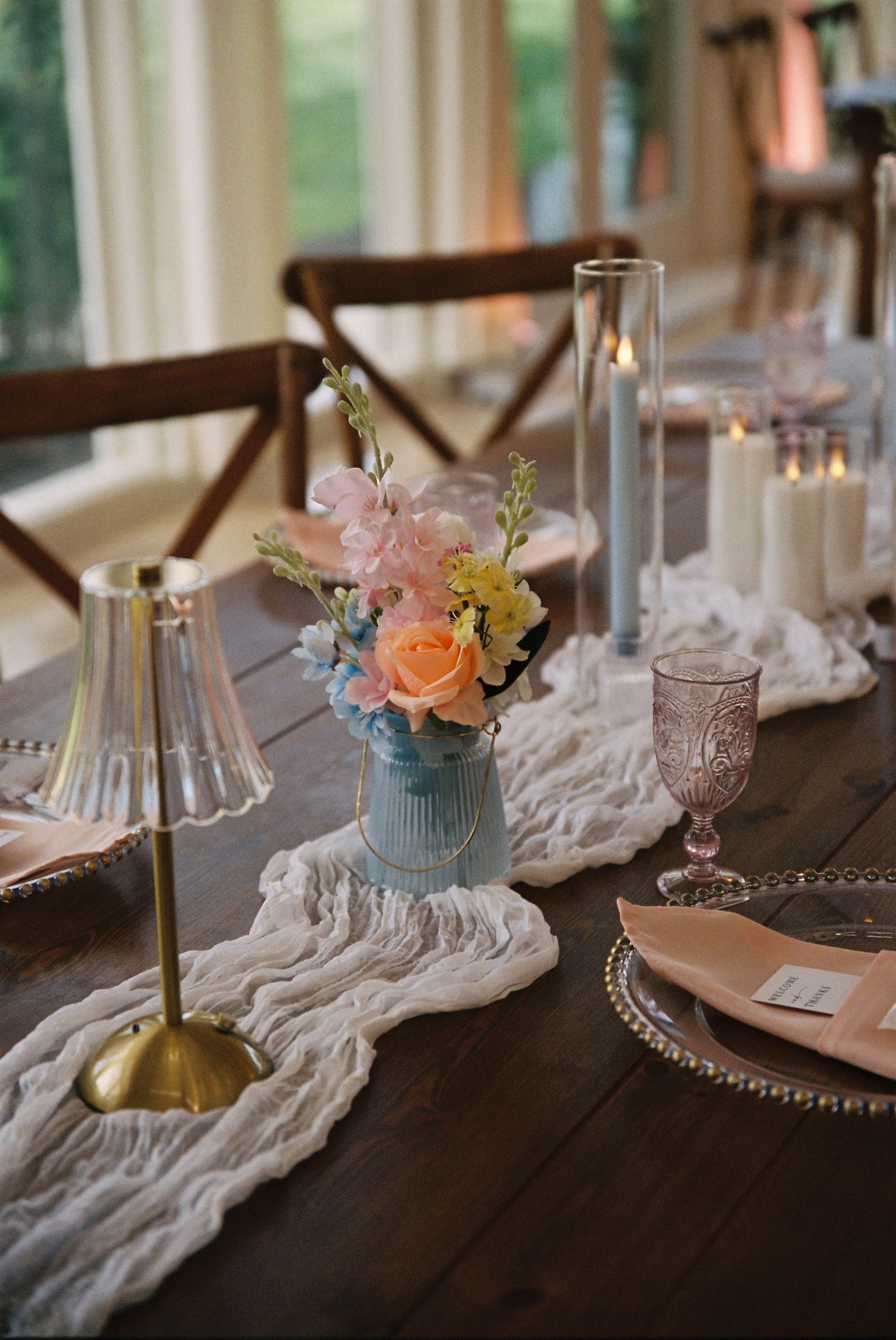 Elegant table settings with white lace runners, crystal glassware, and delicate floral centerpieces create a romantic atmosphere.