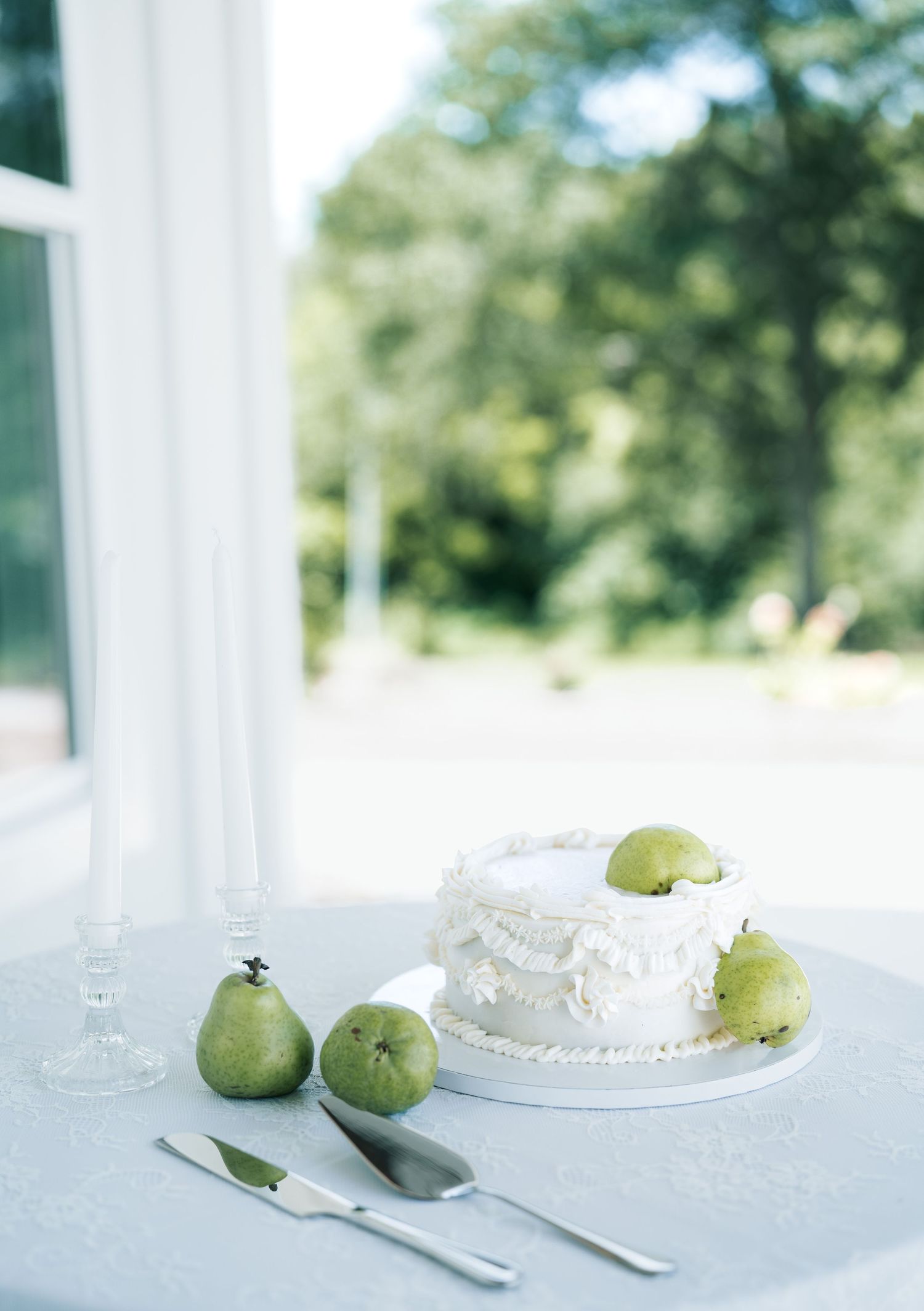 Fresh green apples and table settings arranged on a white surface in bright natural lighting.