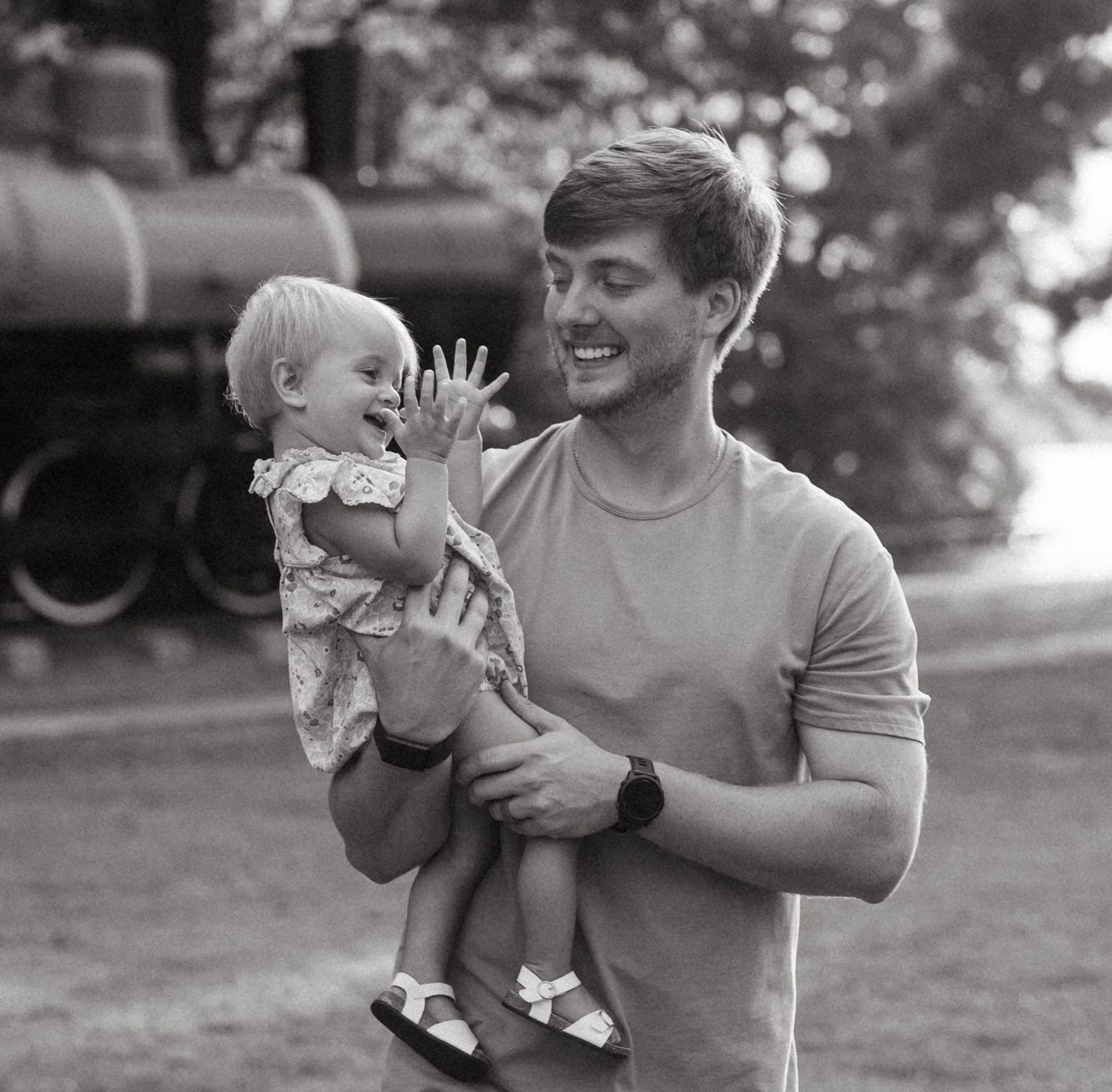 Black and white photos capturing playful moments between parent and child outdoors.