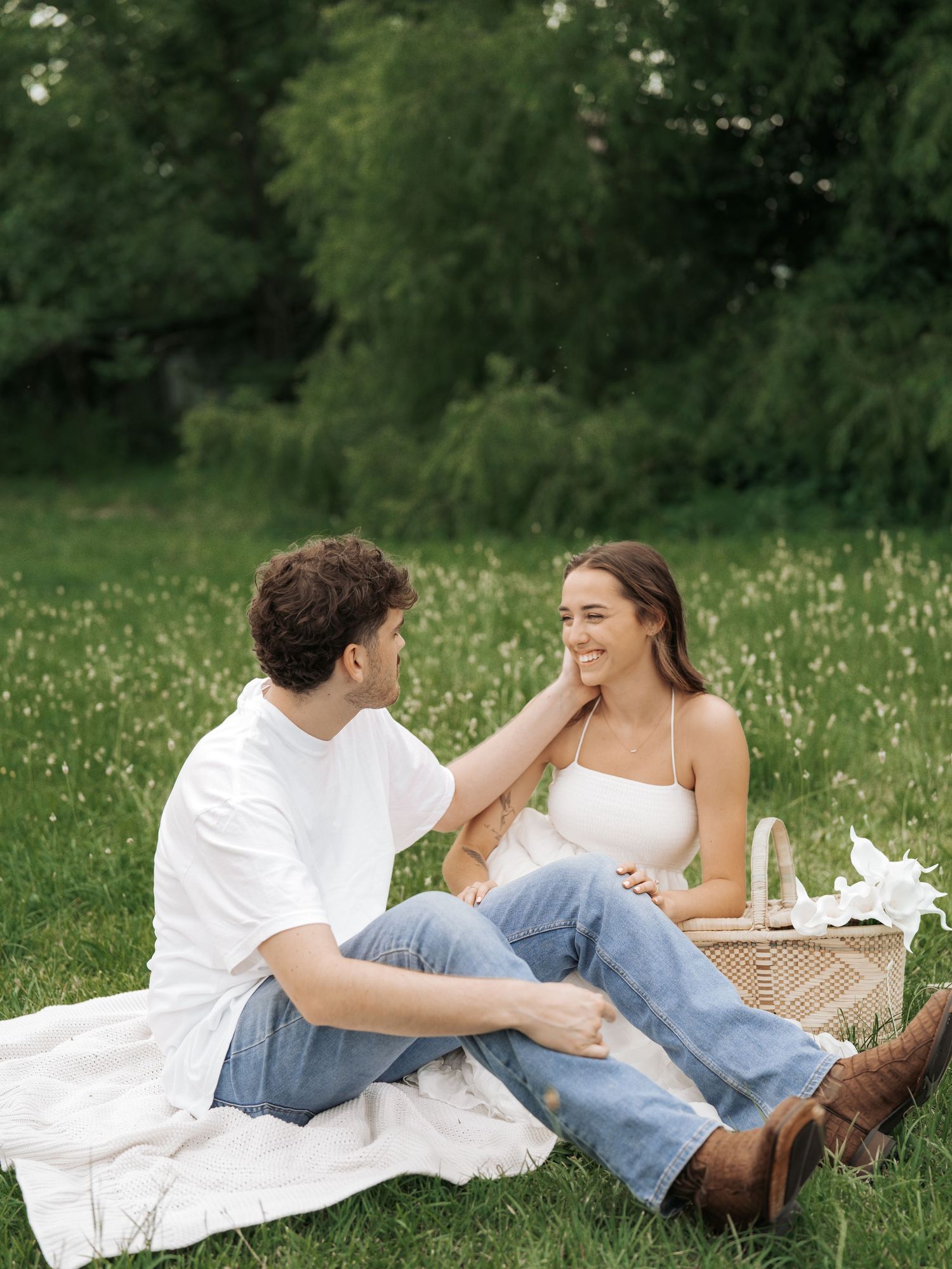 A couple relaxes together on a blanket in a field of wildflowers.