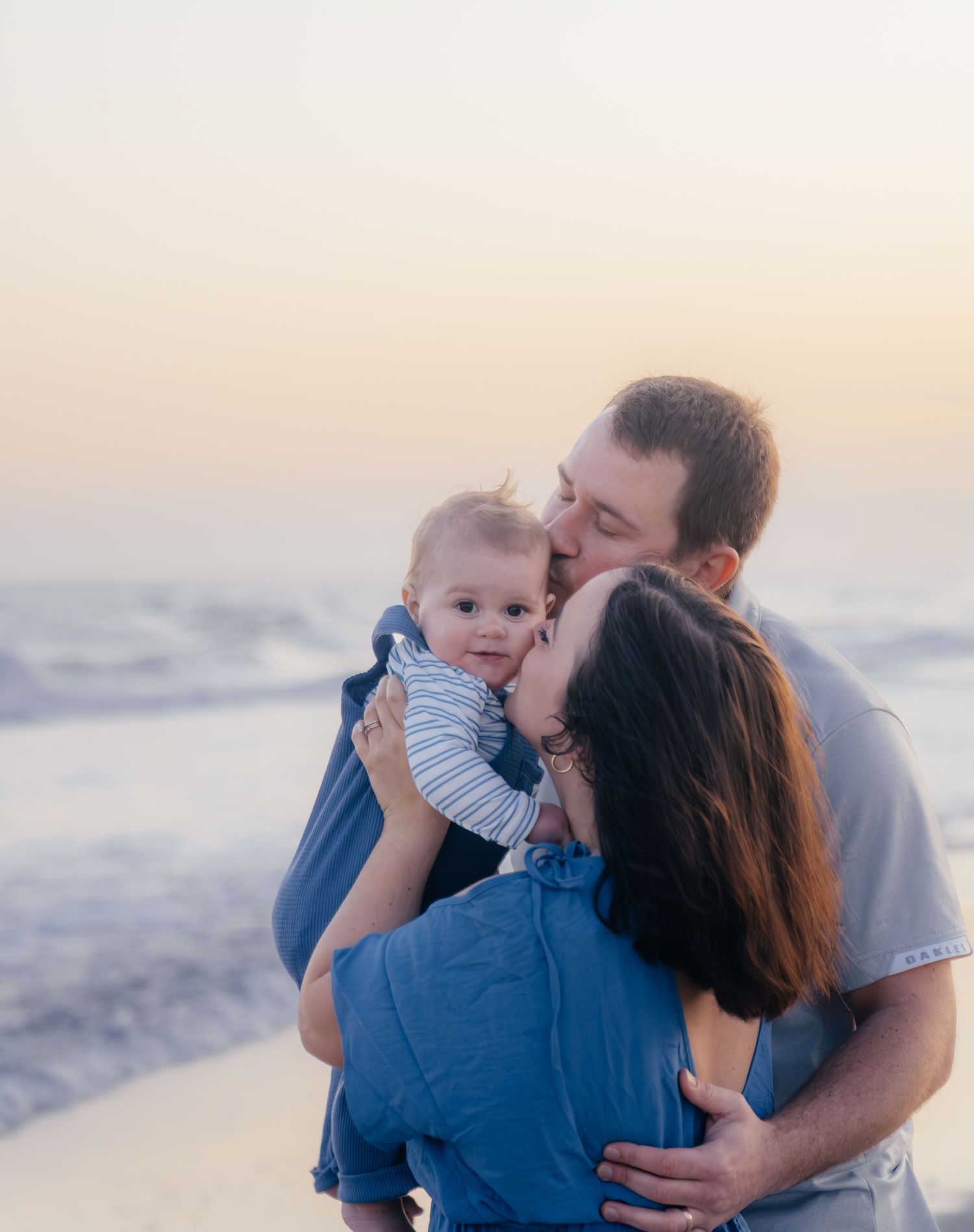Intimate family moment shared on beach during golden hour.