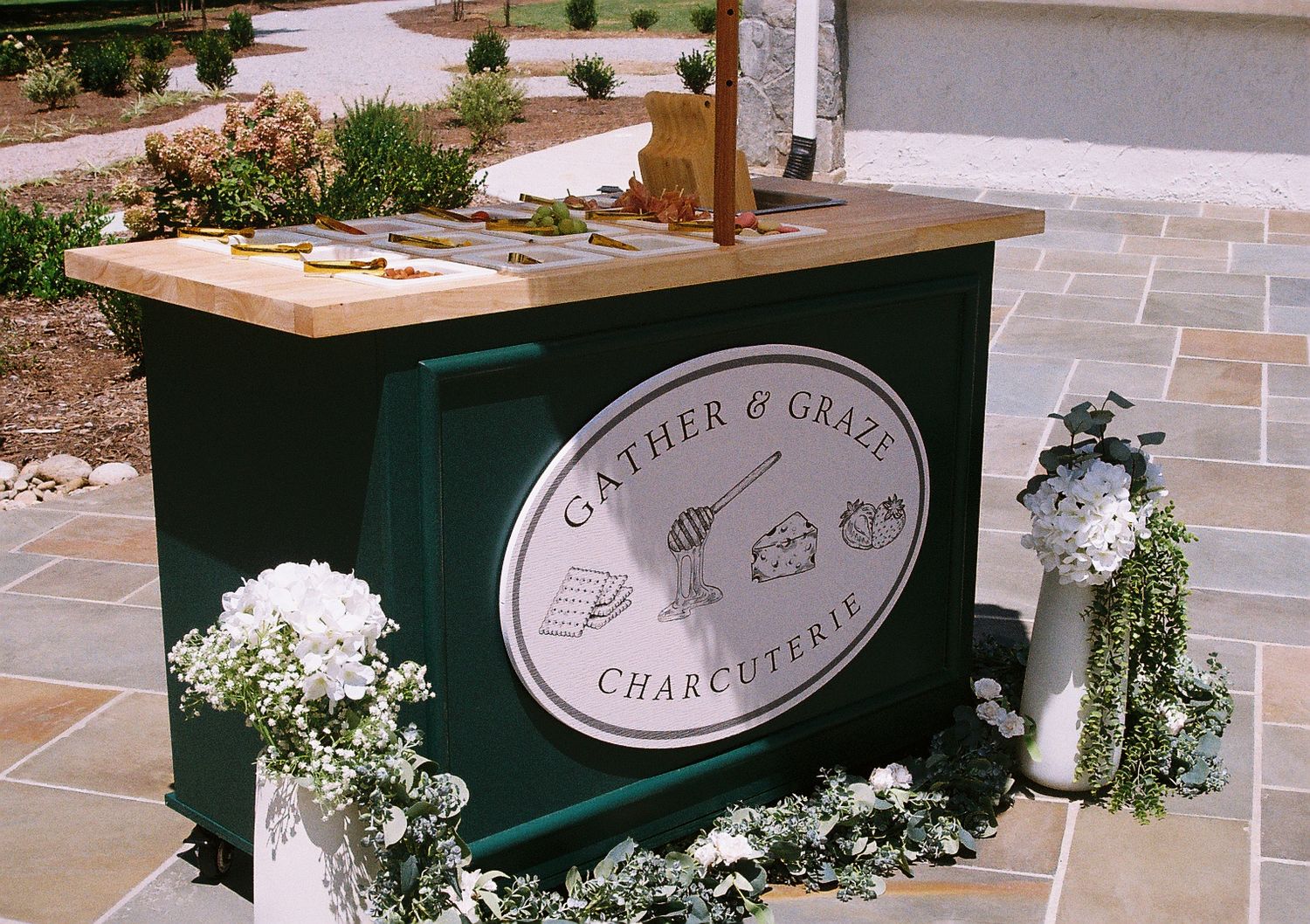 Outdoor catering station with green and white decor elements.