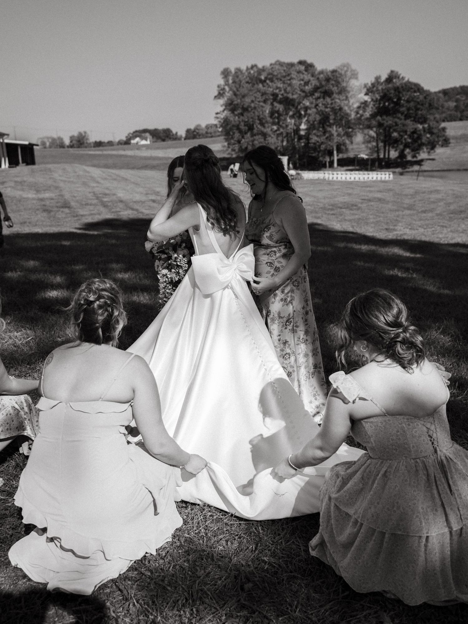 A sequence of black and white photos showing people in formal dresses sitting and interacting outdoors on a sunny day.