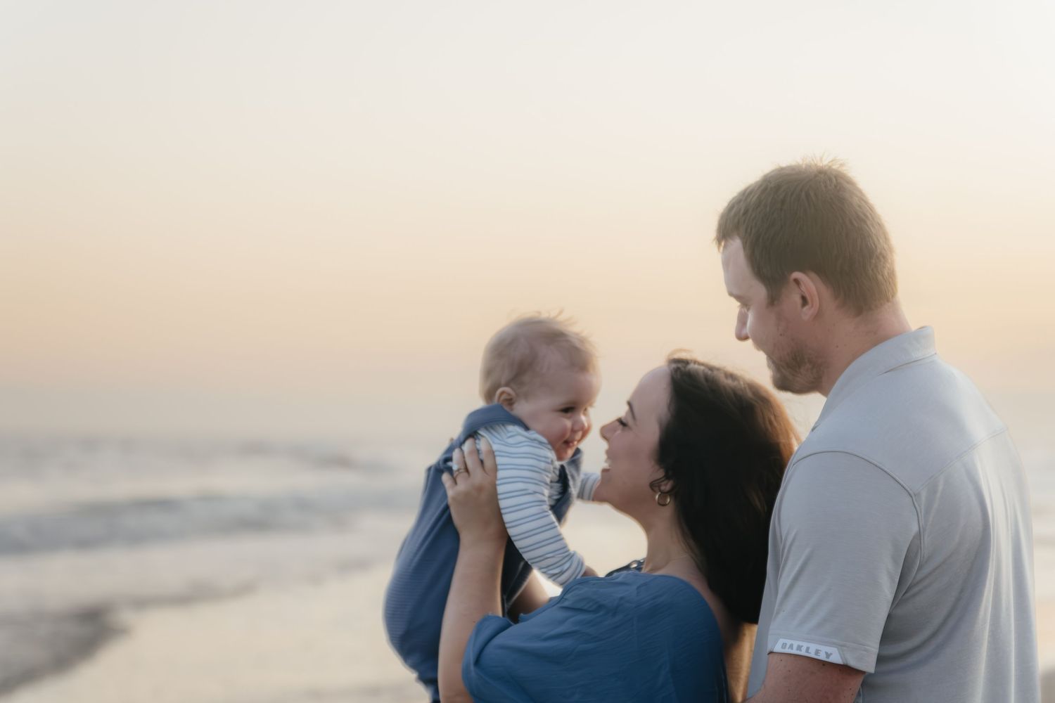 Happy family sharing tender moments on beach at sunset.