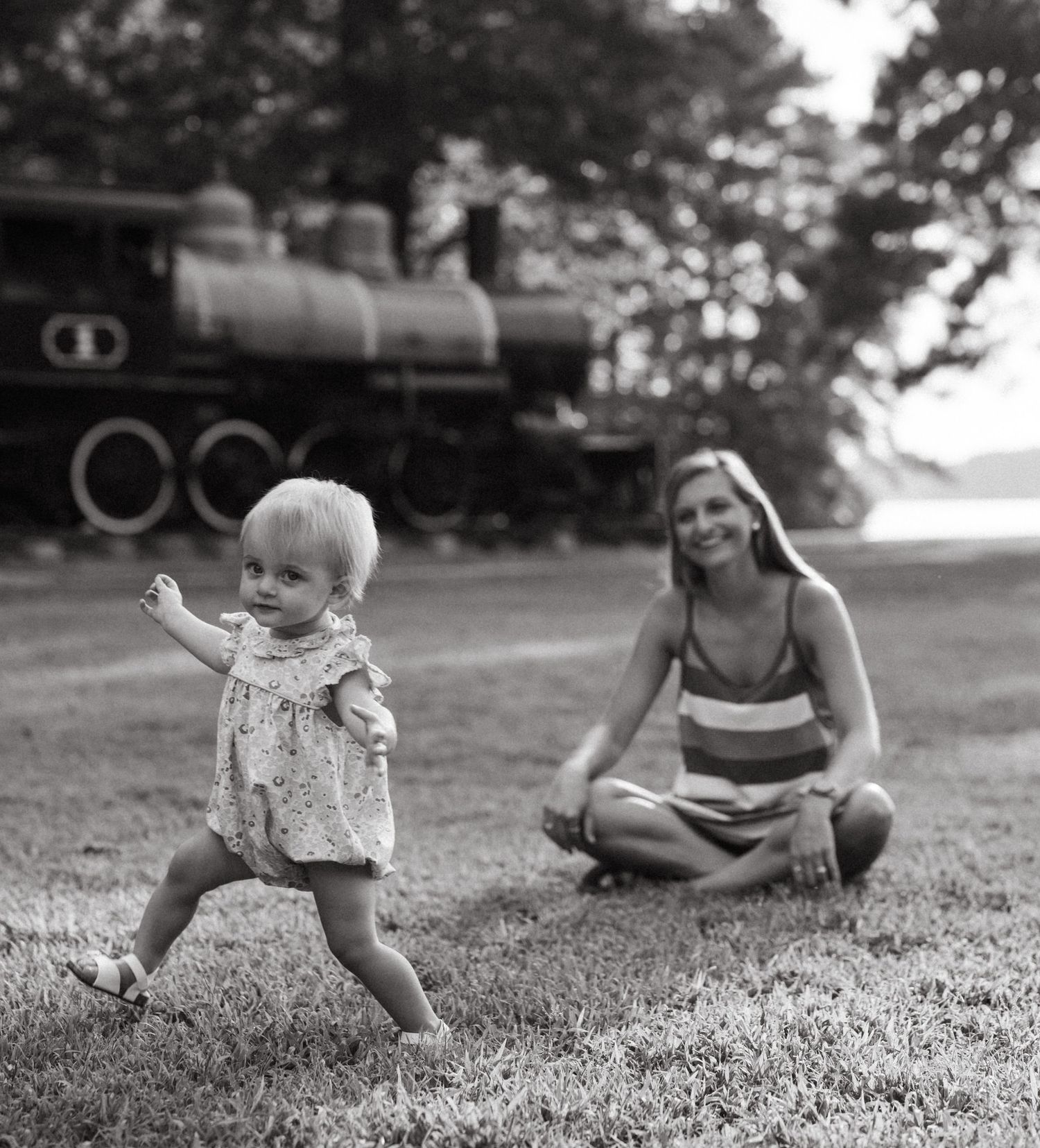 Black and white candid shots of family playing together on grass.