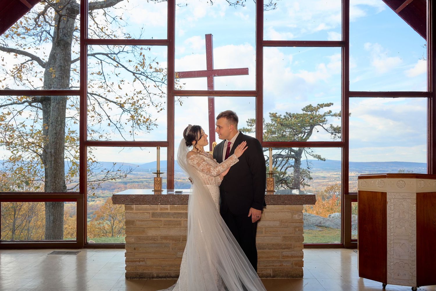 Wedding venue interior with floor-to-ceiling windows overlooking scenic mountain views.