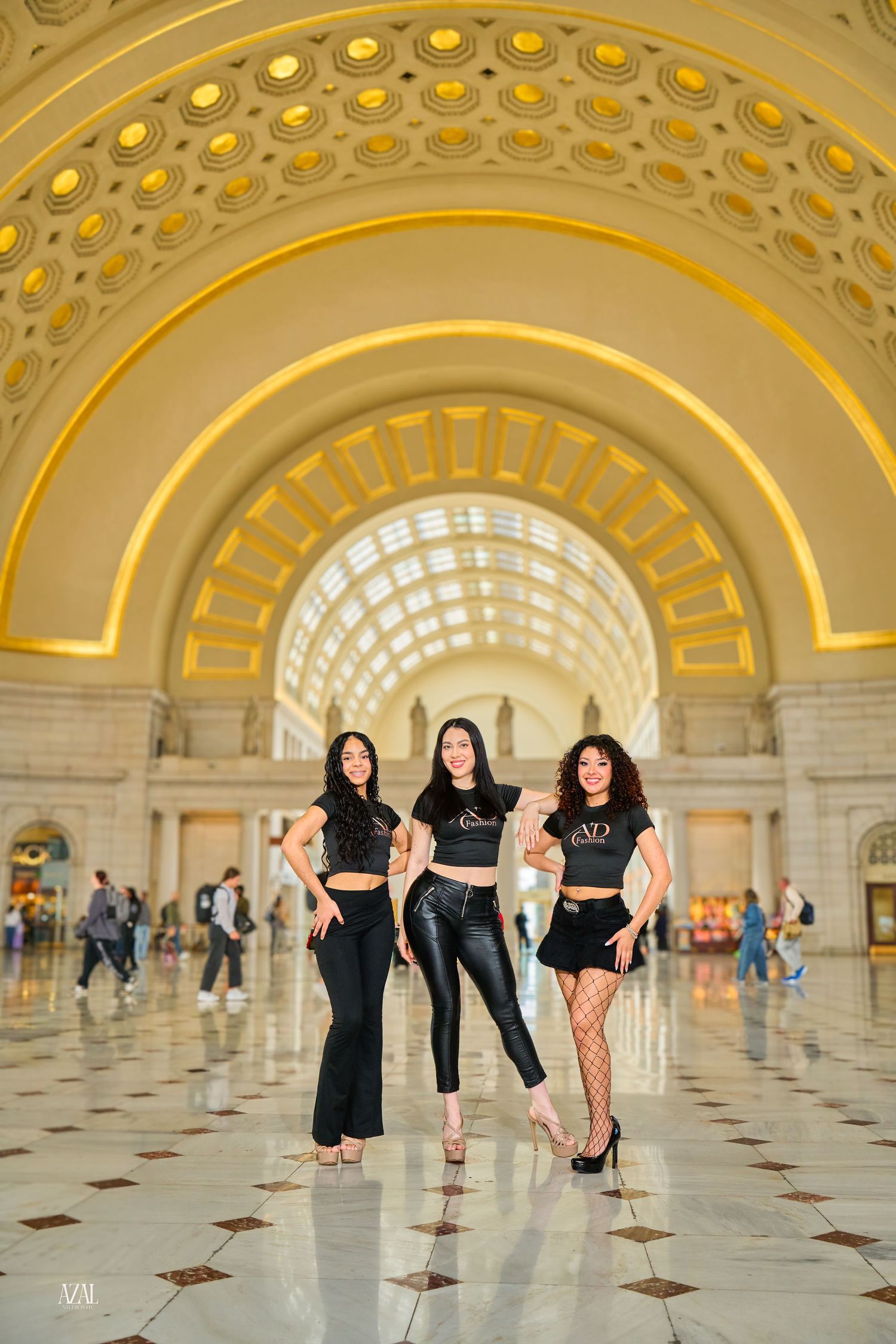 Three women in black outfits pose confidently inside Washington DC Union Station's grand arched hall.