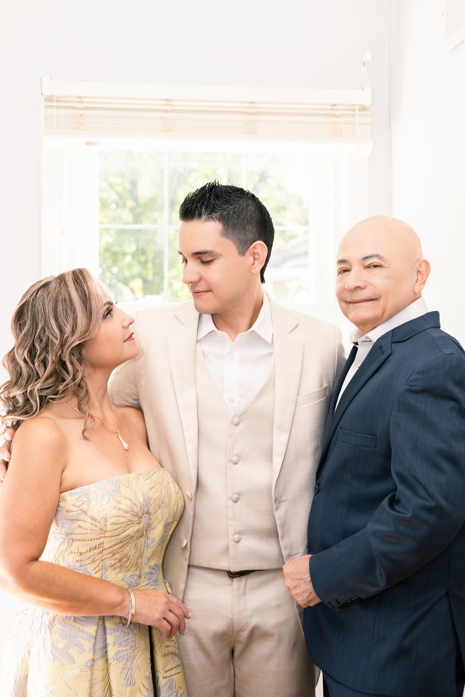 A sequence of four similar wedding party photos showing people in formal attire posing together in a light-filled room.