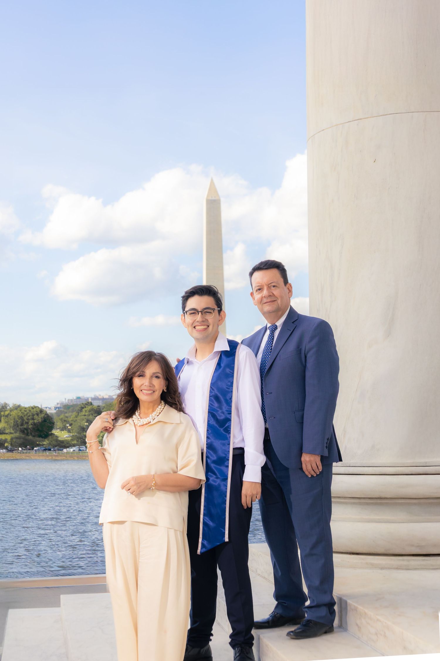 Family photo at Jefferson Memorial with Washington Monument visible in background.