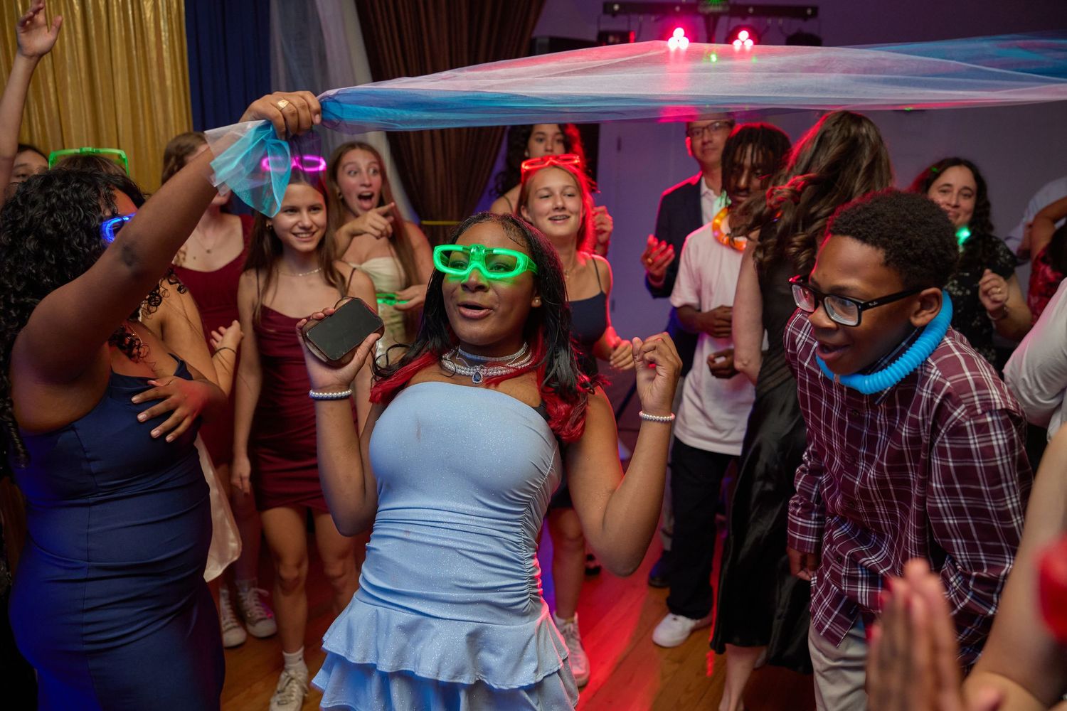 Wedding reception dance floor with colorful lighting and guests dancing in evening celebration.