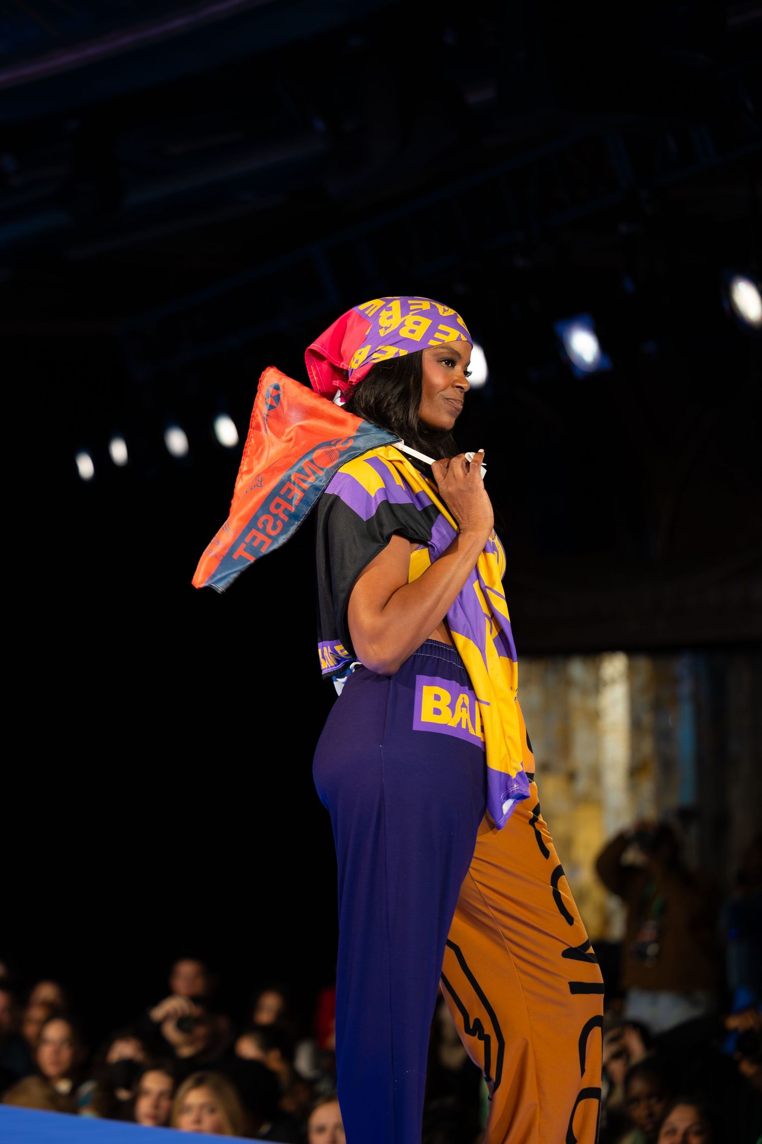 Athletic inspired runway look with colorful headwear and purple performance wear.