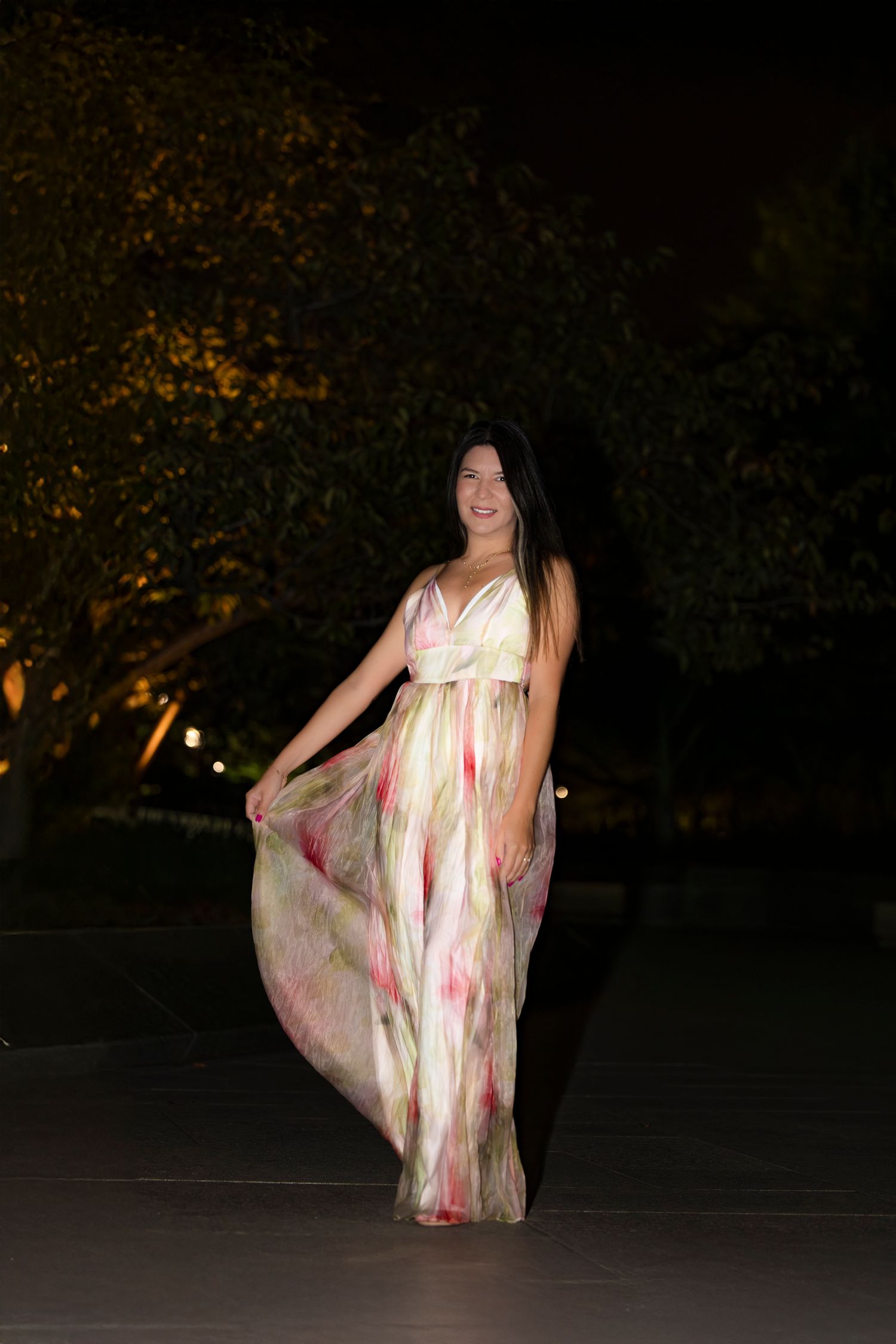 Flowing cream and pink dress captured in evening garden setting.