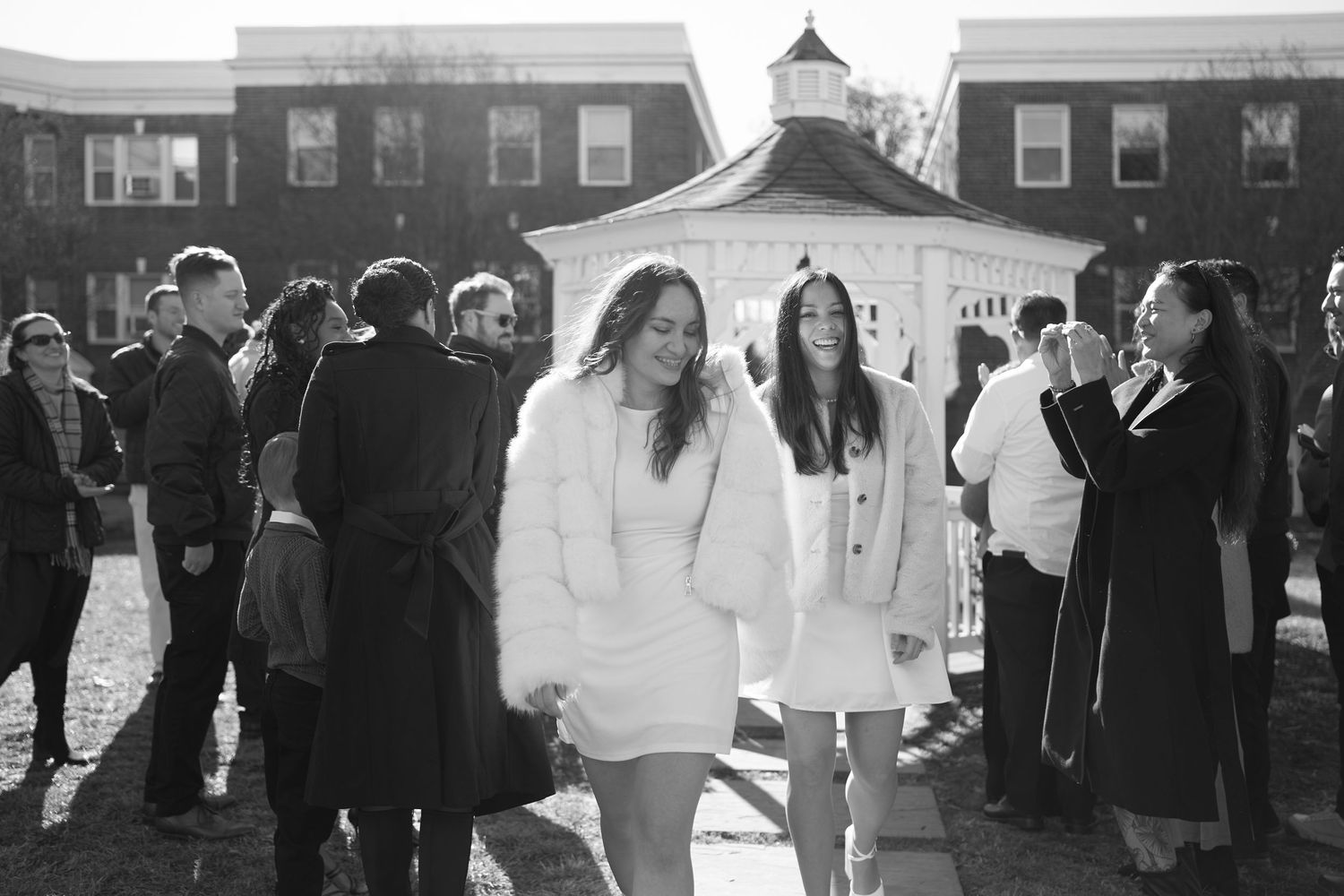 Black and white photo of students gathered outside a campus building with a white cupola in winter.