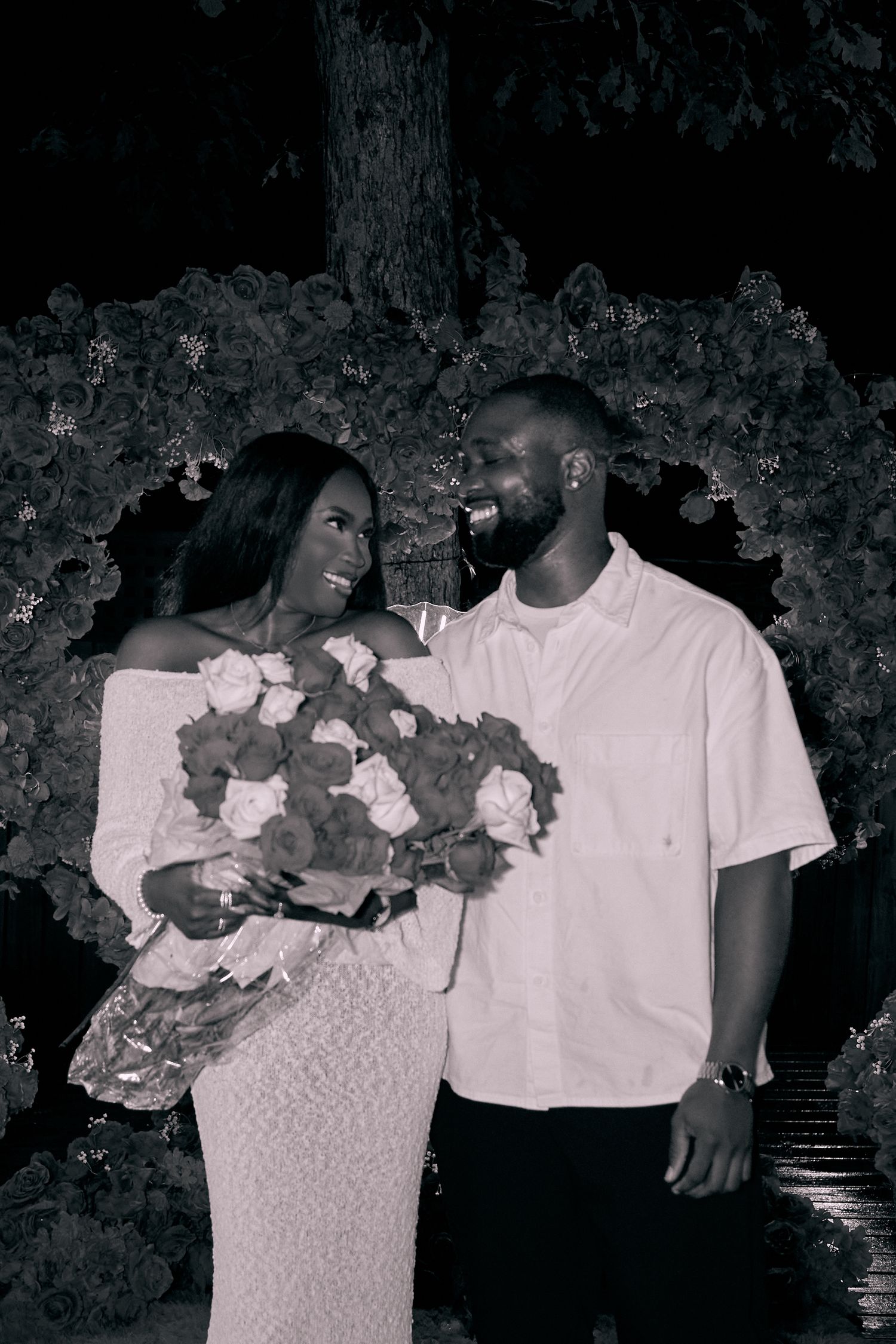 A series of black and white photos showing a couple embracing in romantic poses against a dark background.