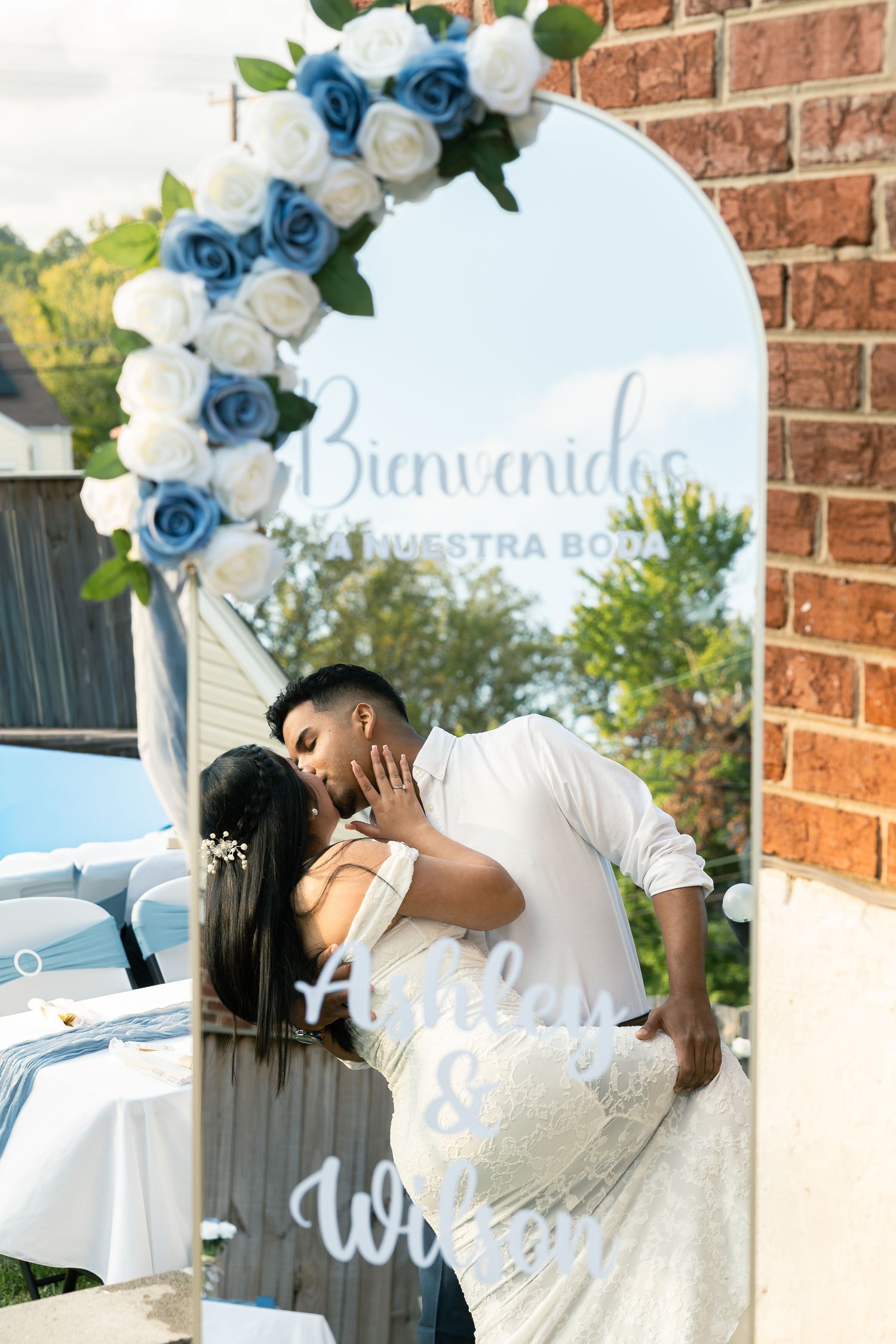 A romantic wedding photo collage with blue and white floral decorations against a brick wall backdrop.