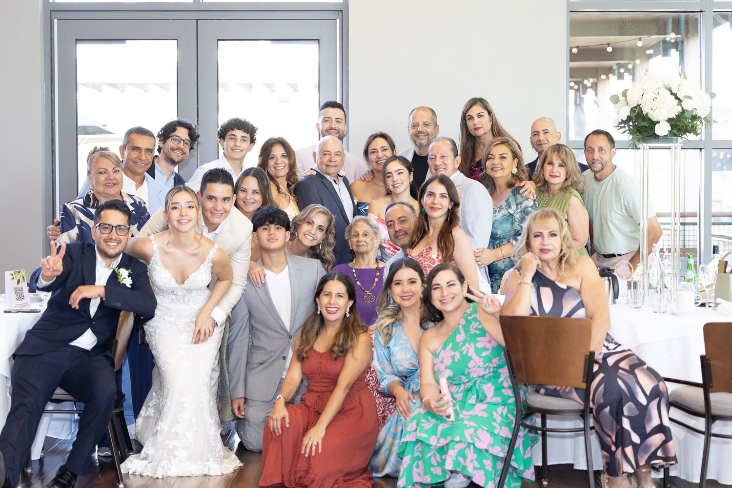 A group of people posing together at a social gathering in a bright indoor space.