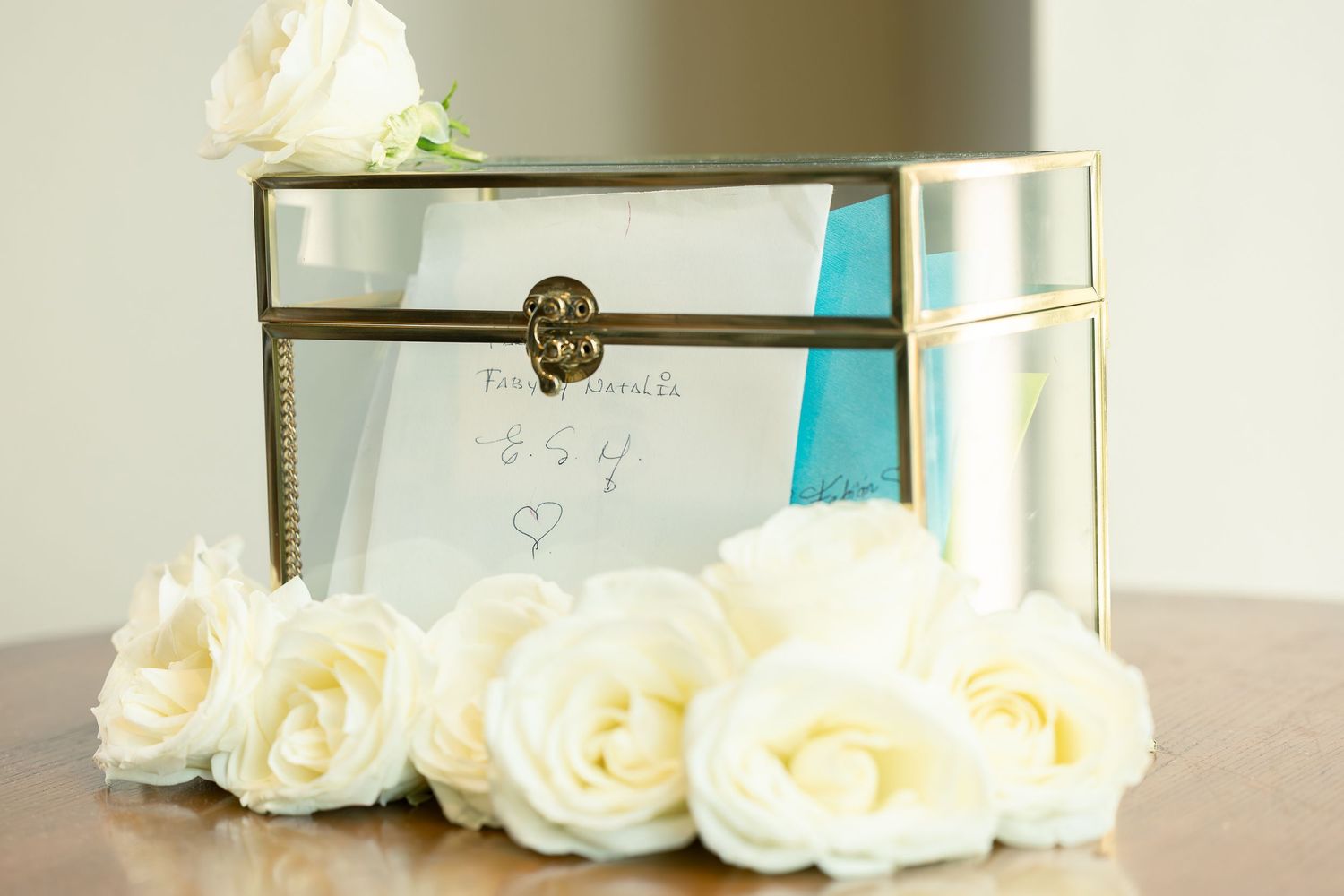 White roses and decorative gold boxes arranged as elegant wedding decor elements.