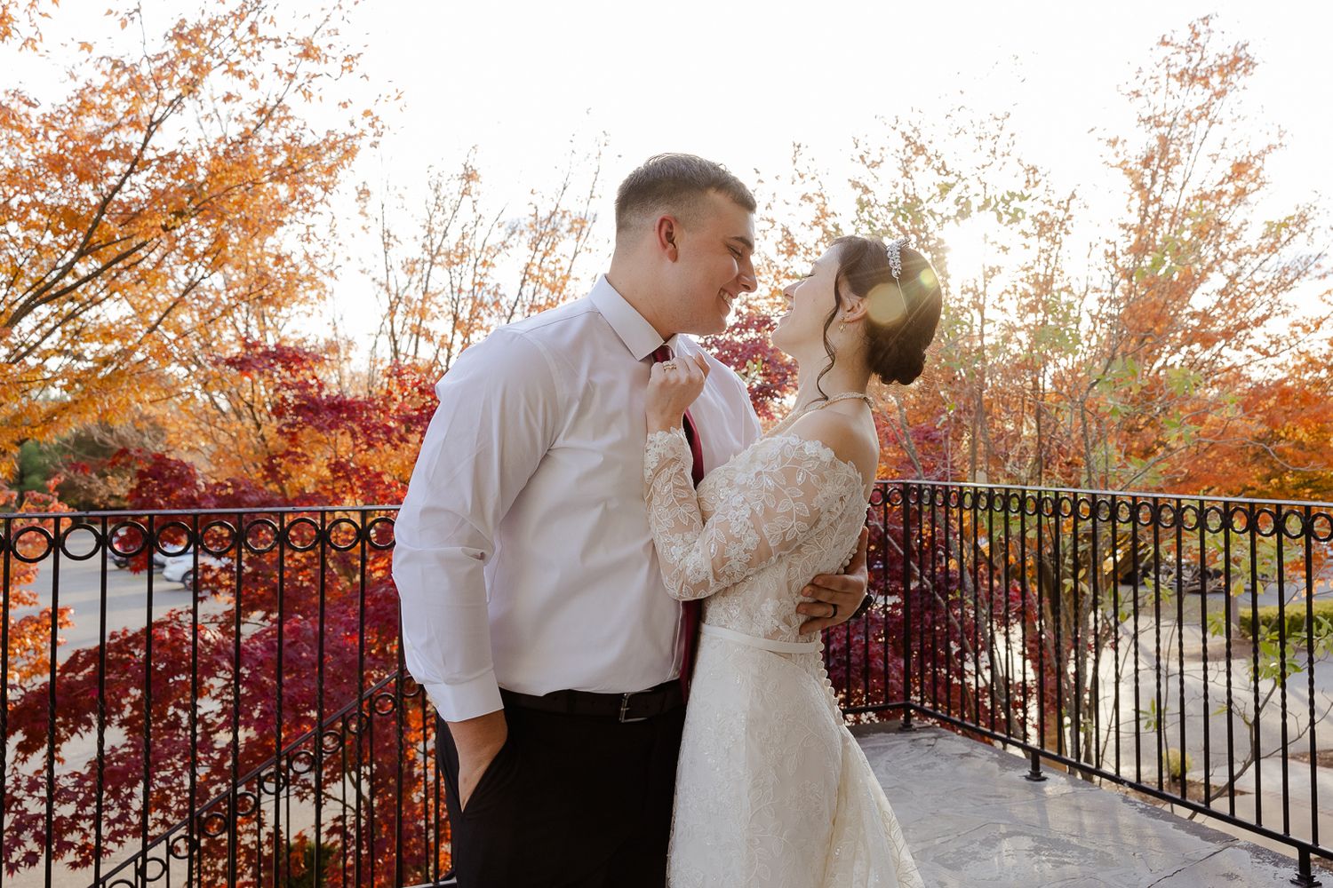 Autumn wedding portraits with fall foliage creating a colorful backdrop behind the couple.