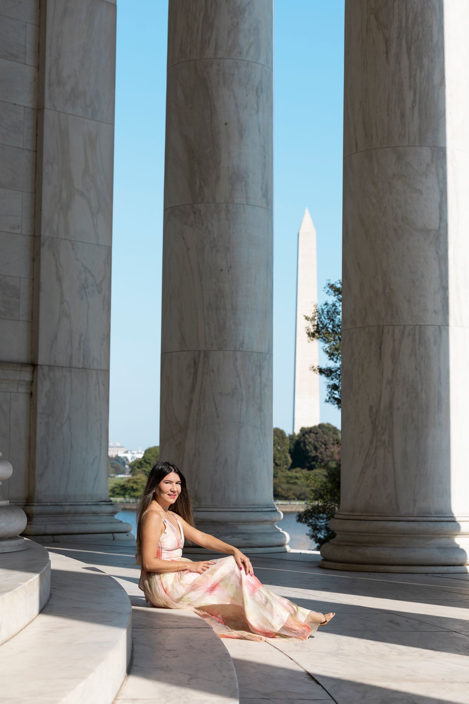 Flowing dress photographed at Jefferson Memorial with Washington Monument visible between columns.