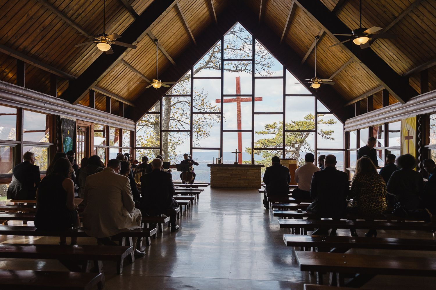 Interior view of a modern cafeteria with wooden beams and large windows showing natural light.