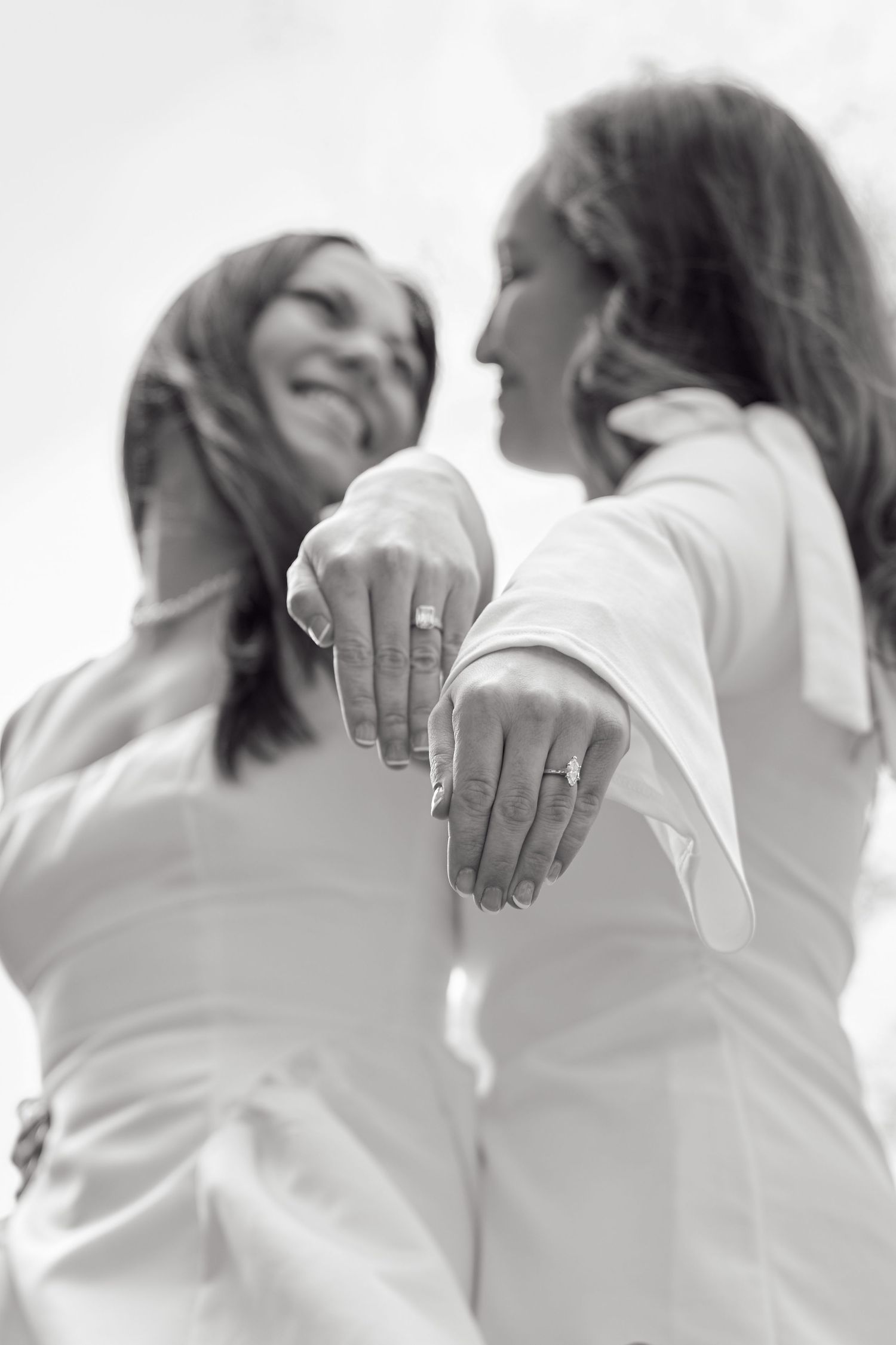 A series of hands on shoulders in a cascading line of people wearing white.