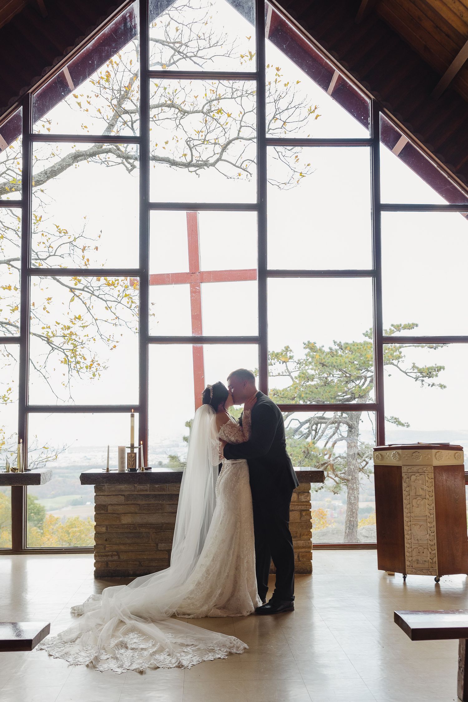 A sequence of photos showing a couple in wedding attire by large windows in an architectural setting.