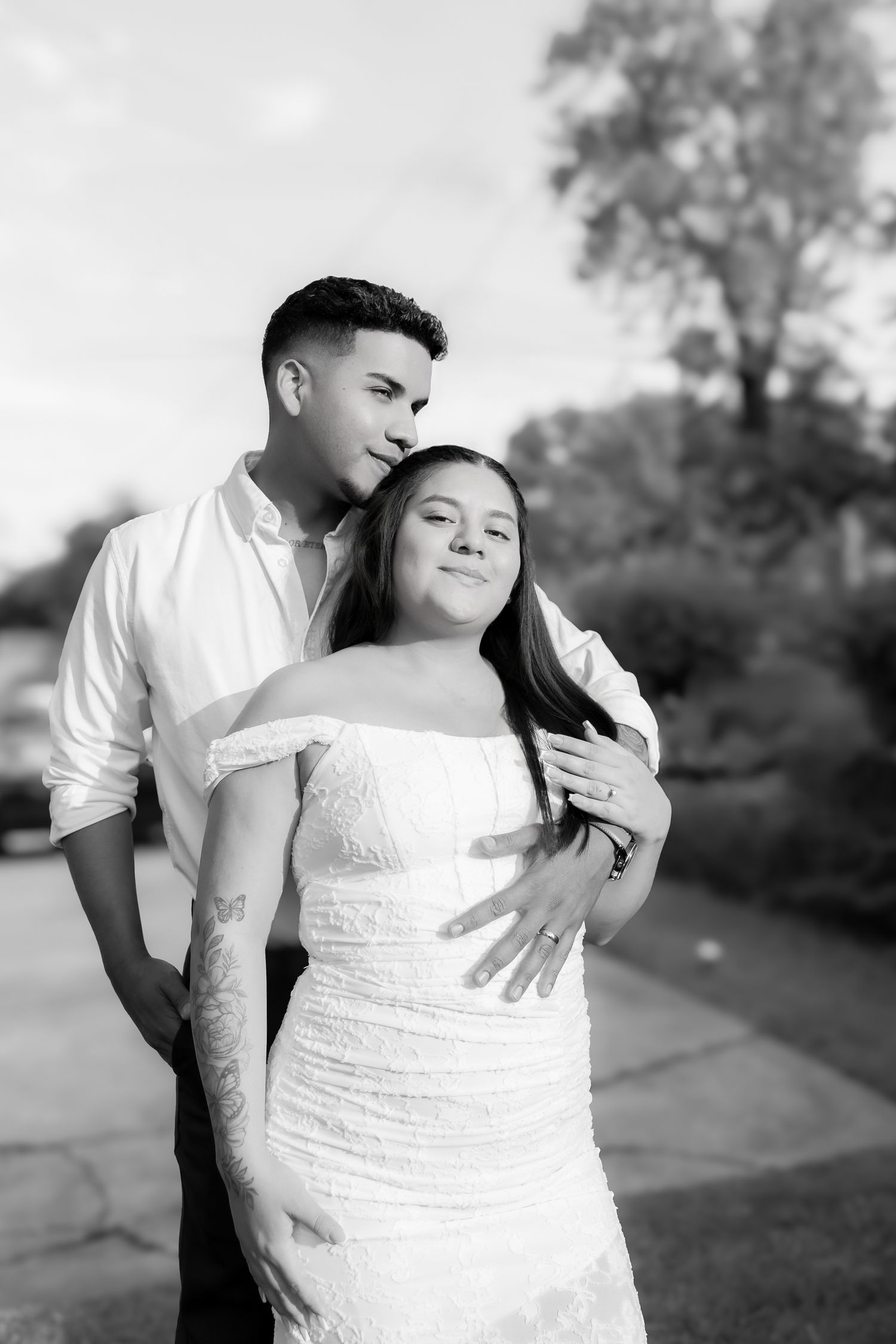 A romantic black and white photo series showing intimate moments between a couple in formal wedding attire outdoors.