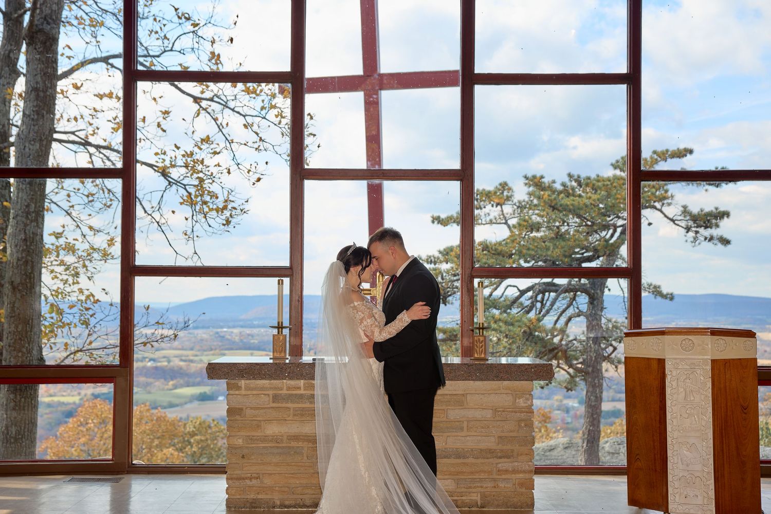 Modern indoor wedding venue with floor-to-ceiling windows showcasing mountain views and wooden accents.