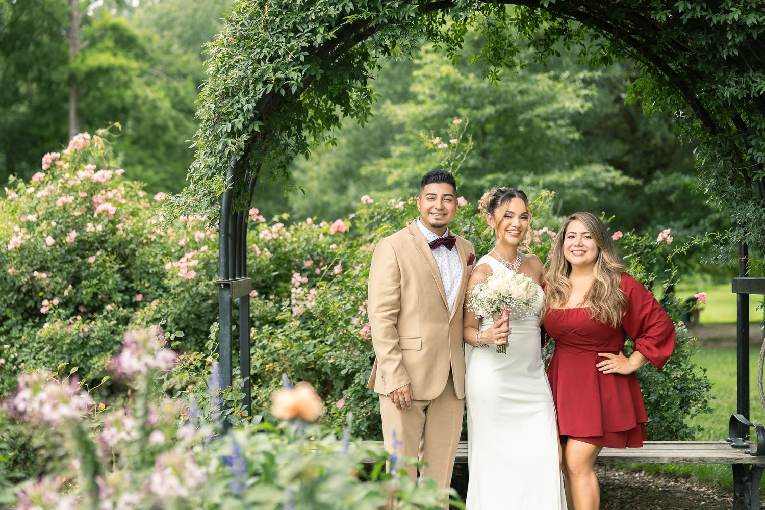 Romantic portraits captured in a garden gazebo surrounded by vibrant summer flowers and greenery.