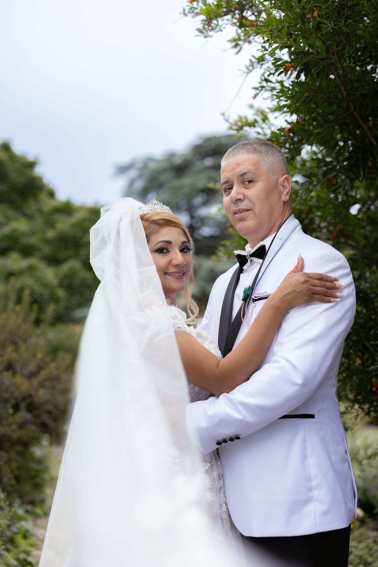 A couple shares an intimate dance moment during their outdoor wedding celebration in formal wedding attire.