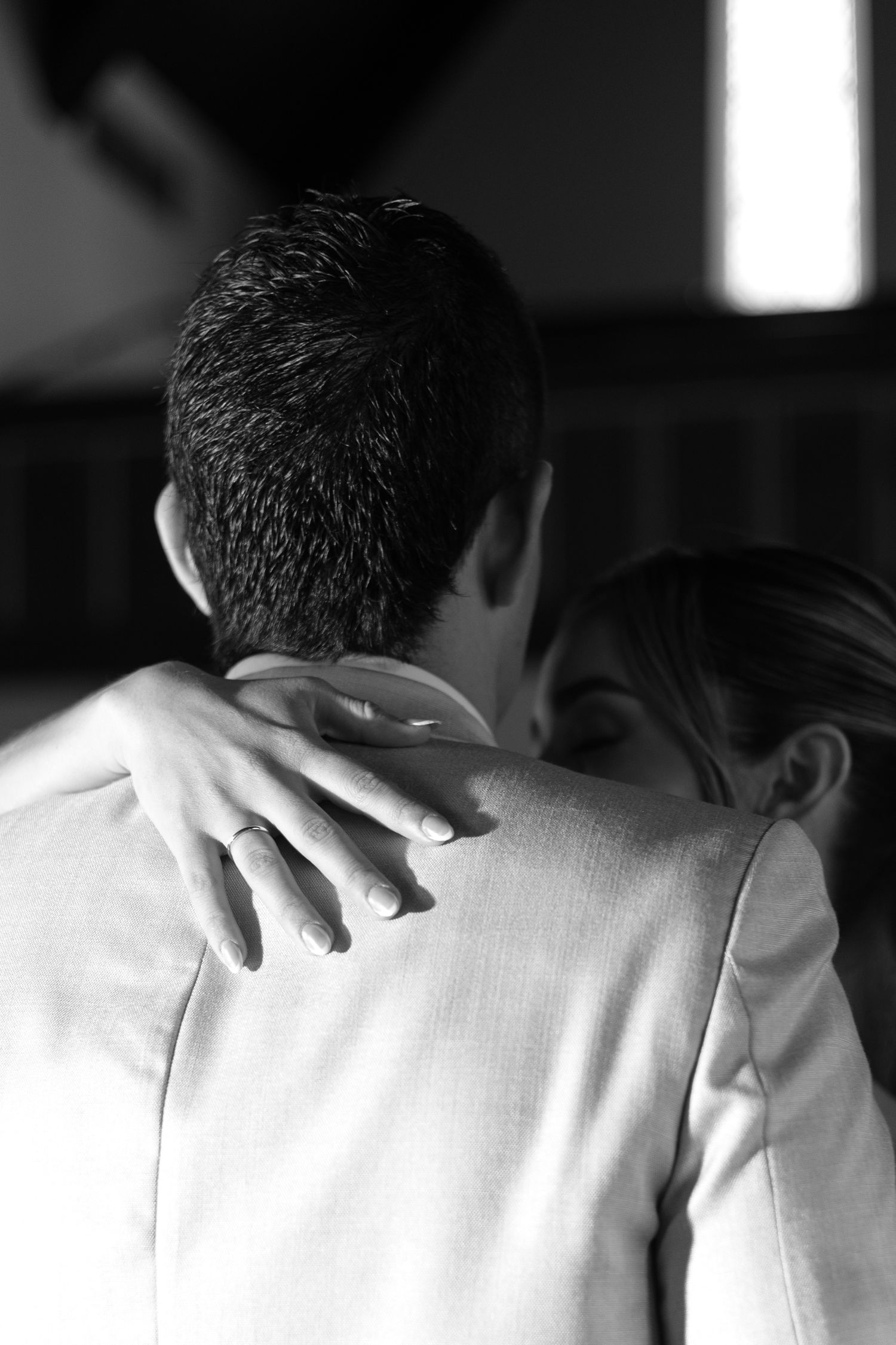 A series of black and white photographs showing a person in a white shirt being comforted with hands on their shoulders.