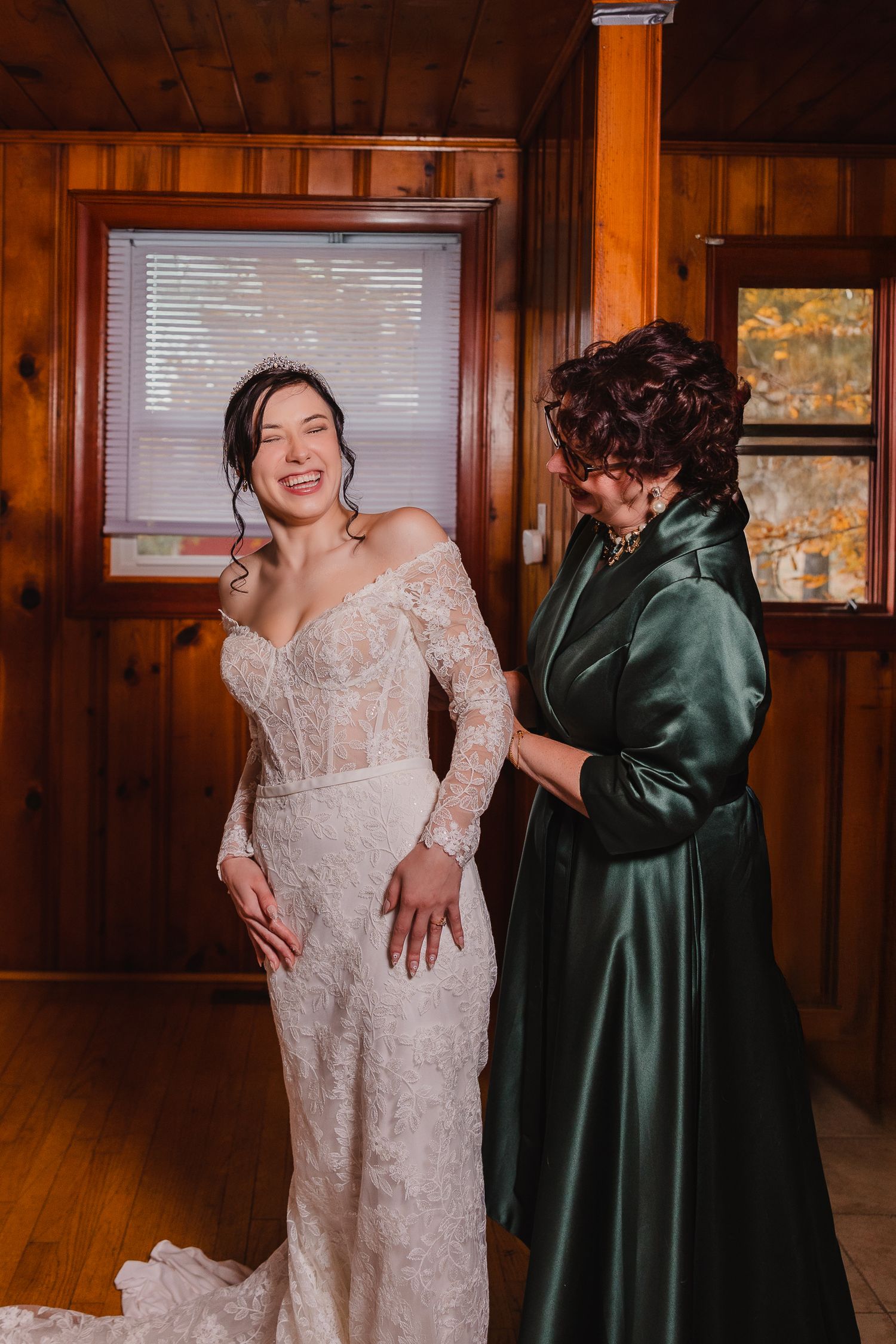 Wedding party members sharing emotional reactions and embraces in a wood-paneled room.