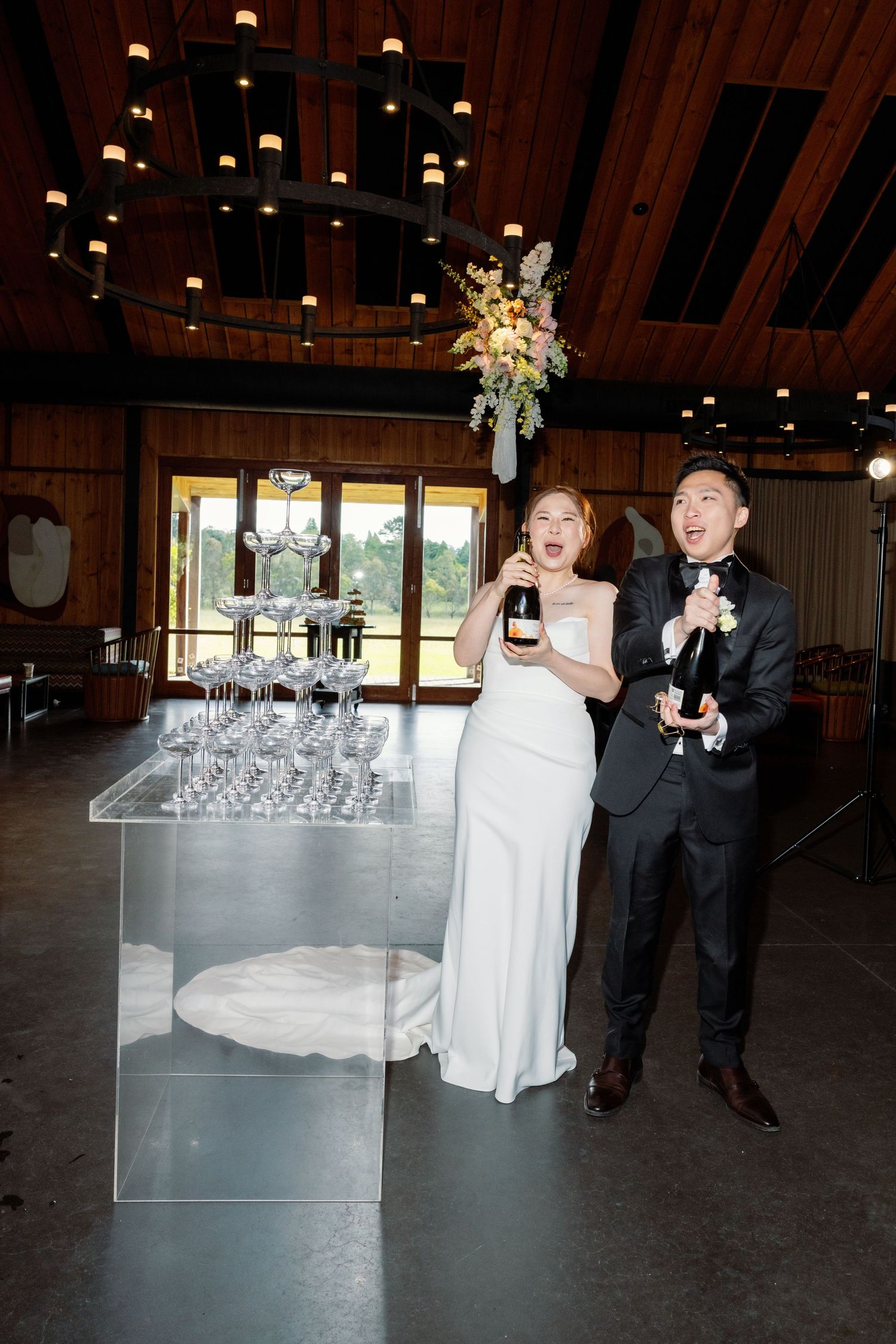 Wedding reception scene in a barn venue with champagne glasses and elegant table settings.