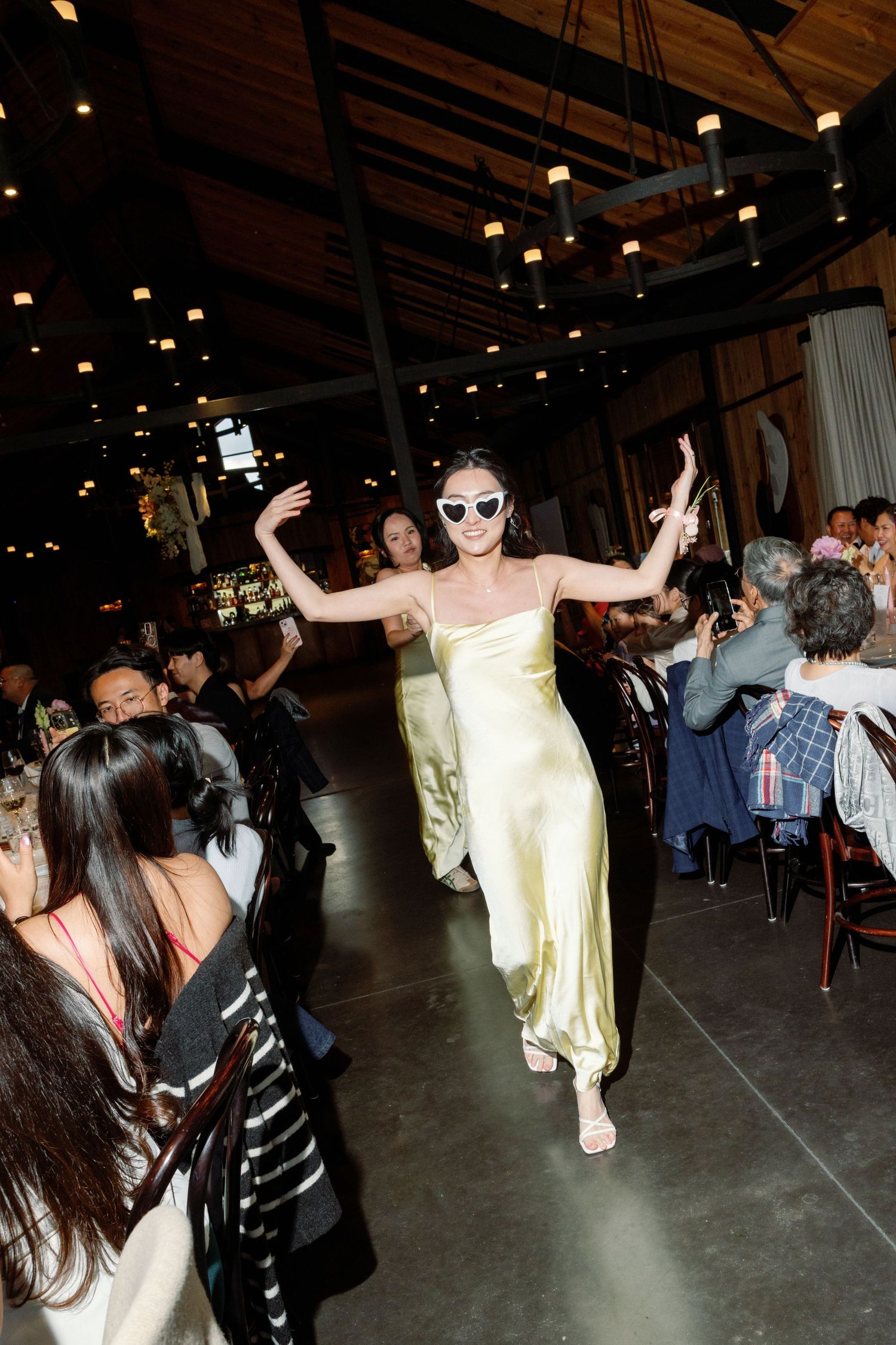 People dancing and celebrating in a dimly lit event space with festive atmosphere.