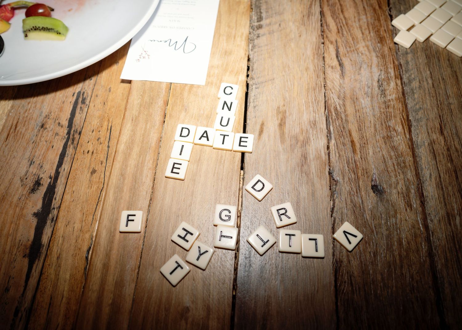 Scrabble letter tiles spelling out words on a rustic wooden table surface.