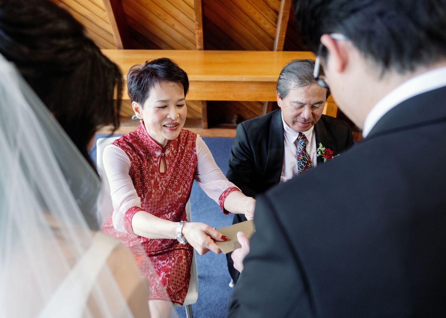 Wedding ceremony attendees seated in wooden pews during indoor service.