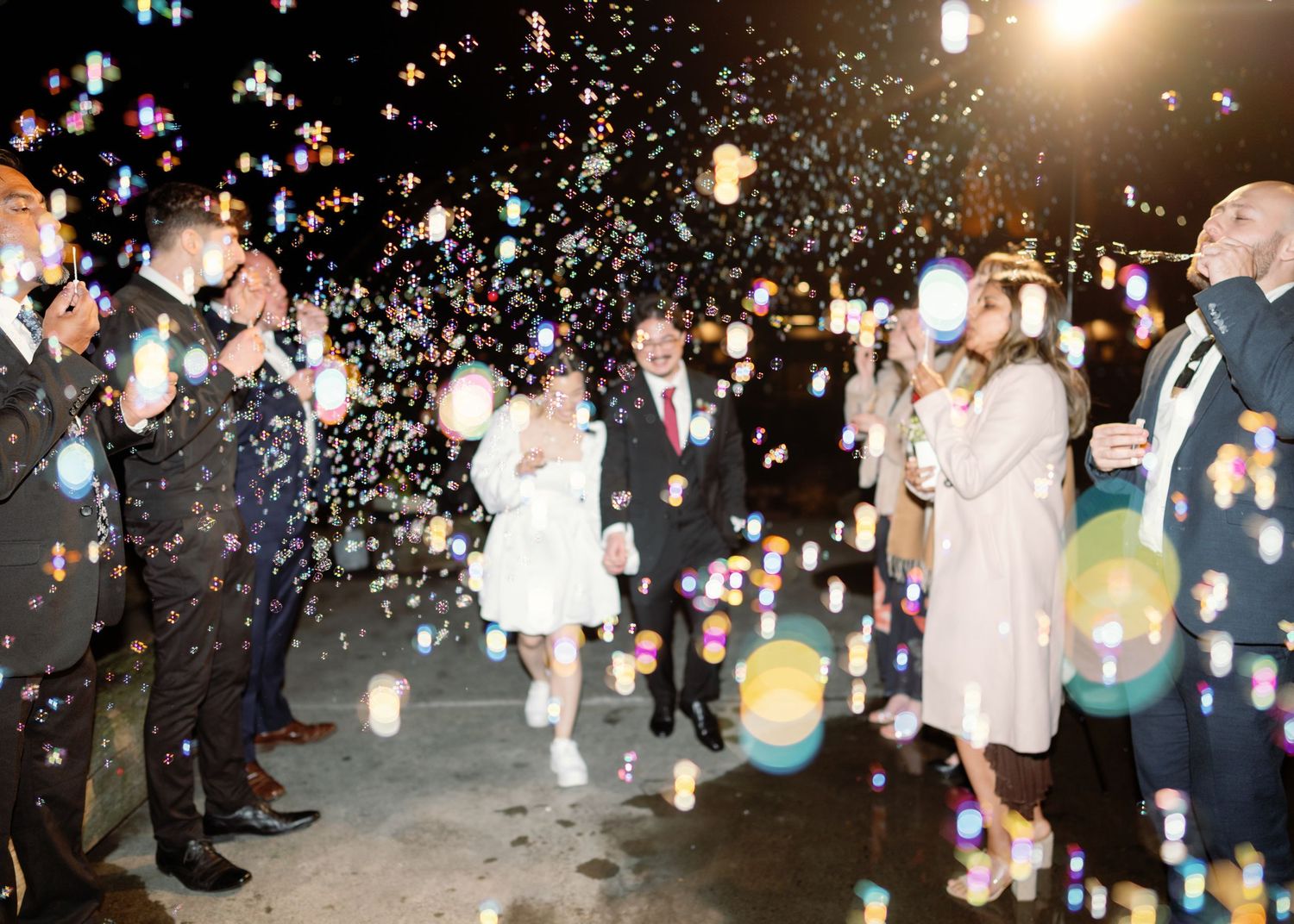 Nighttime wedding celebration with colorful confetti and sparklers creating a magical atmosphere.