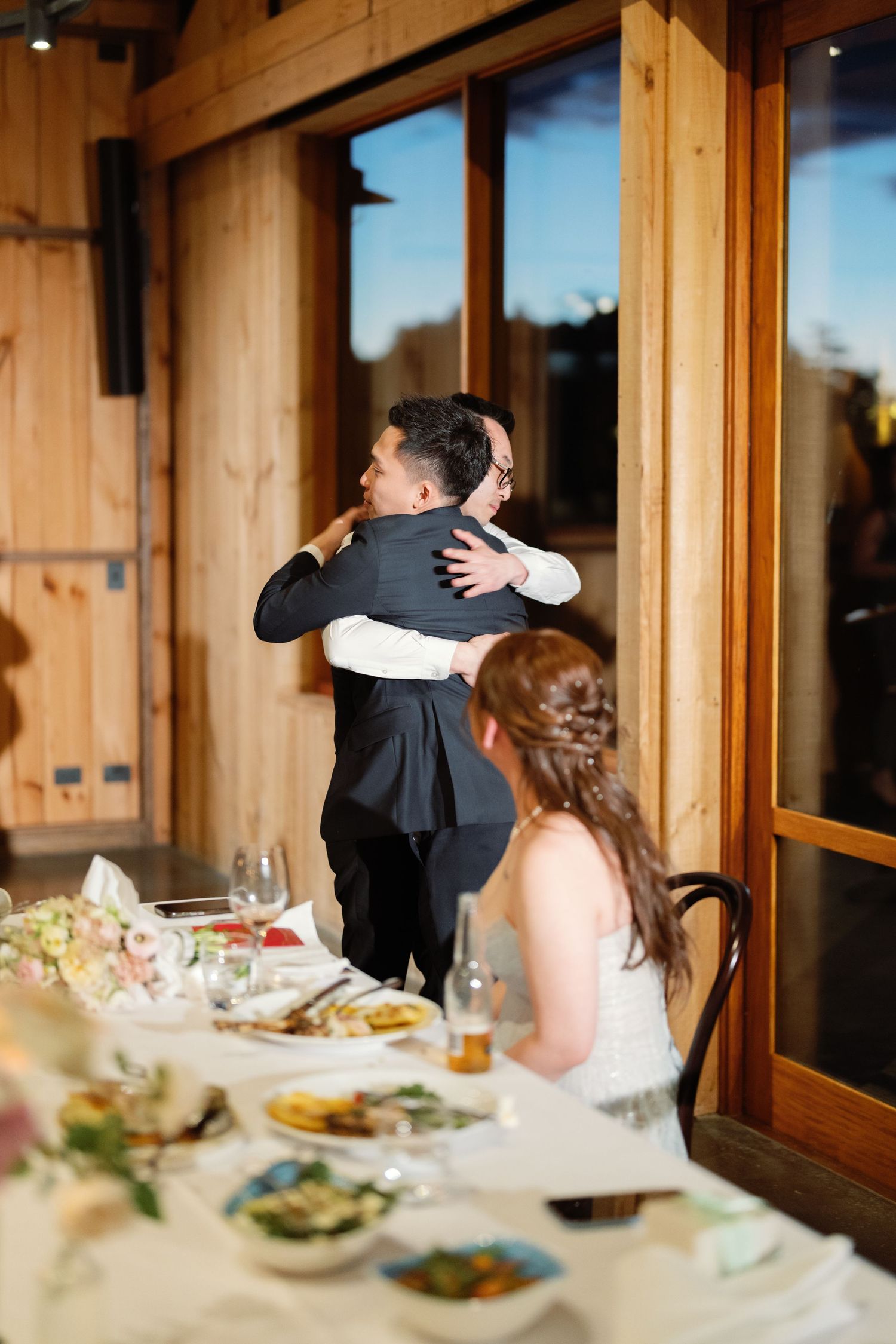 Elegant table settings with floral centerpieces in a rustic wooden venue.