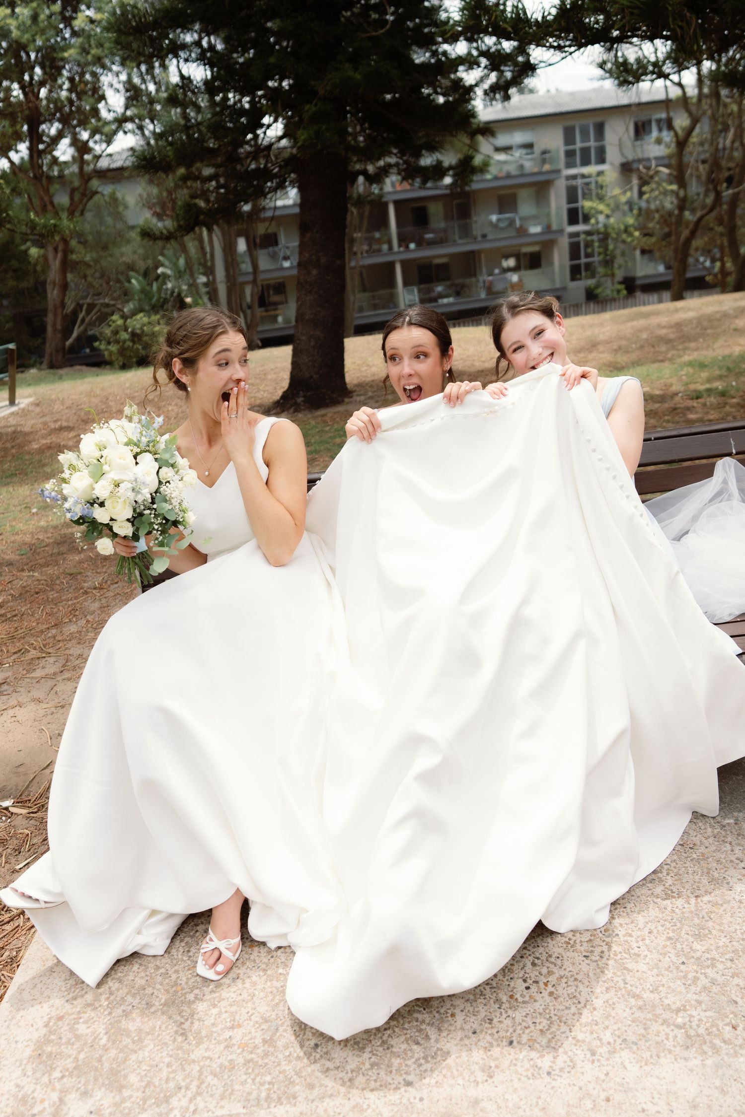 A sequence of playful wedding photos showing a couple sitting on the ground with flowing white dress fabric.