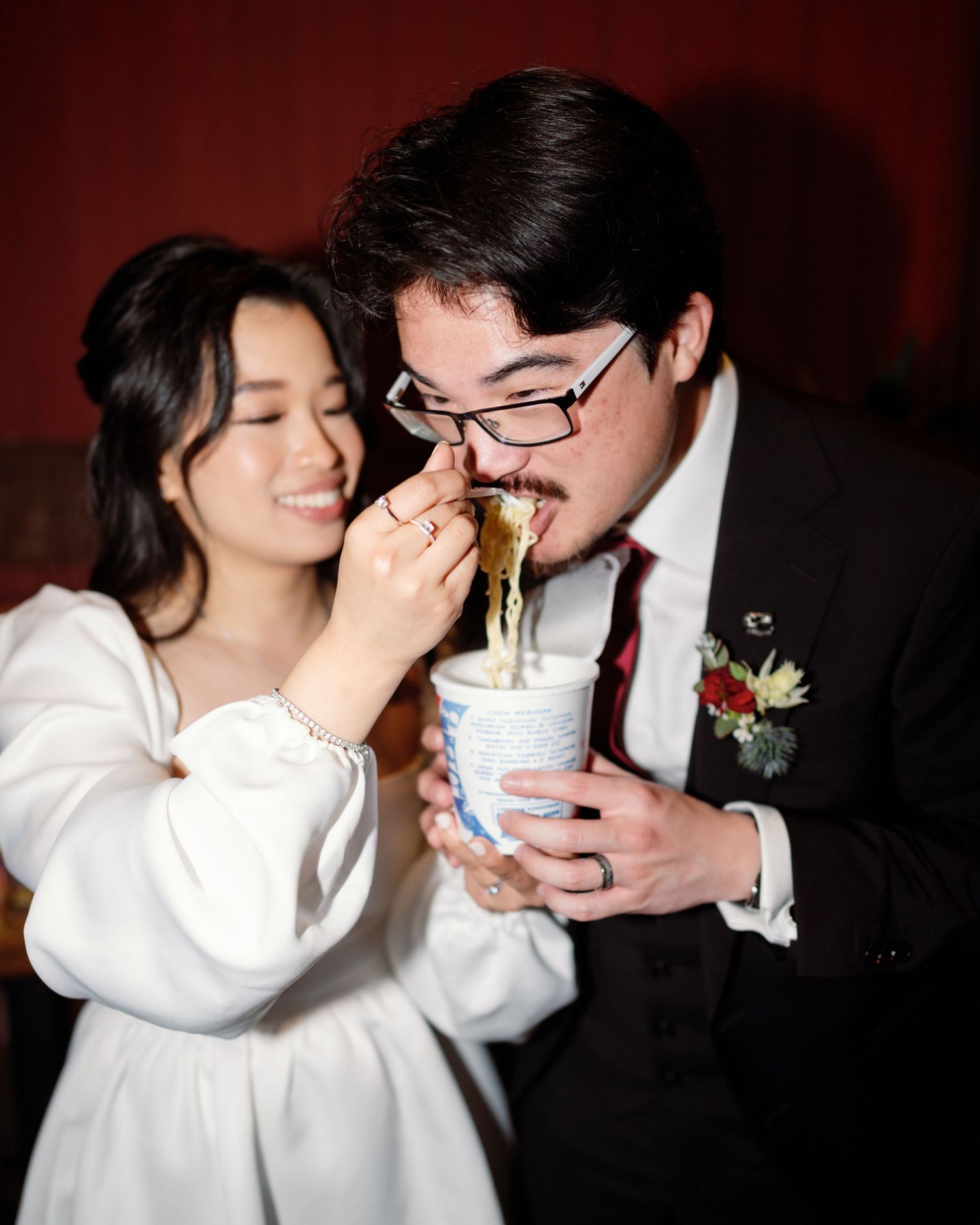 A couple shares drinks and laughter during an intimate wedding moment.