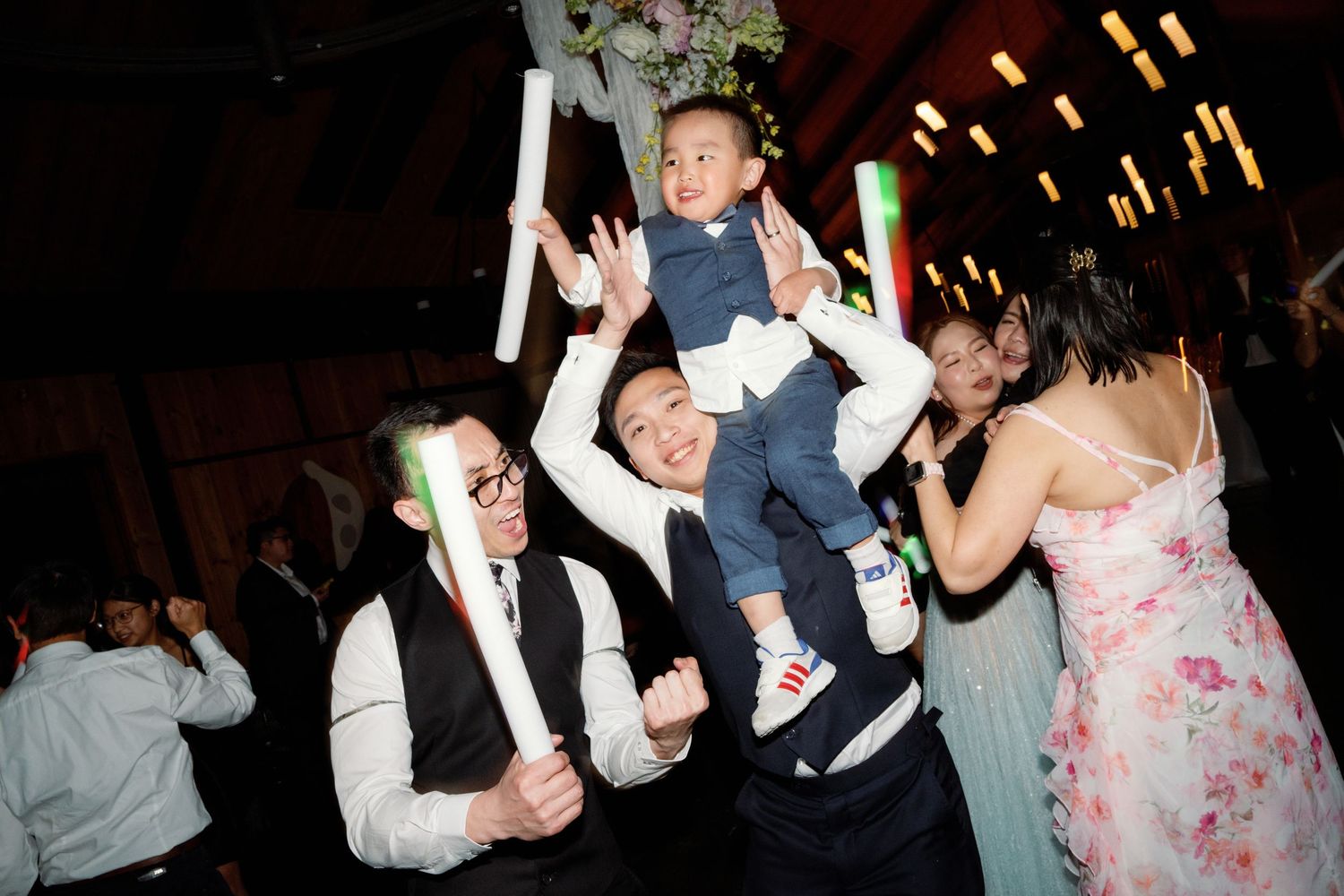 Wedding reception dance floor with guests celebrating under warm lighting.