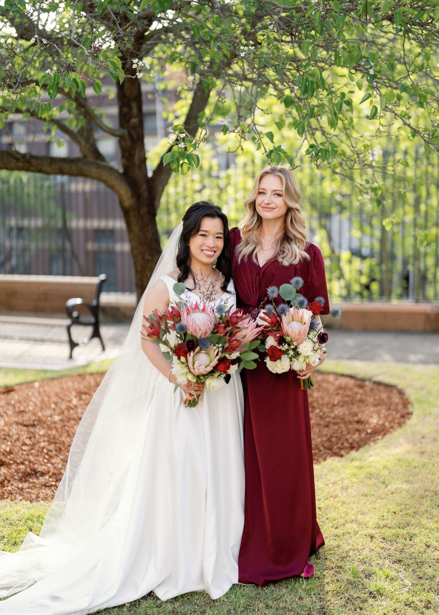 Wedding party photos showing bride in white dress and bridesmaid in burgundy gown posing outdoors under trees.